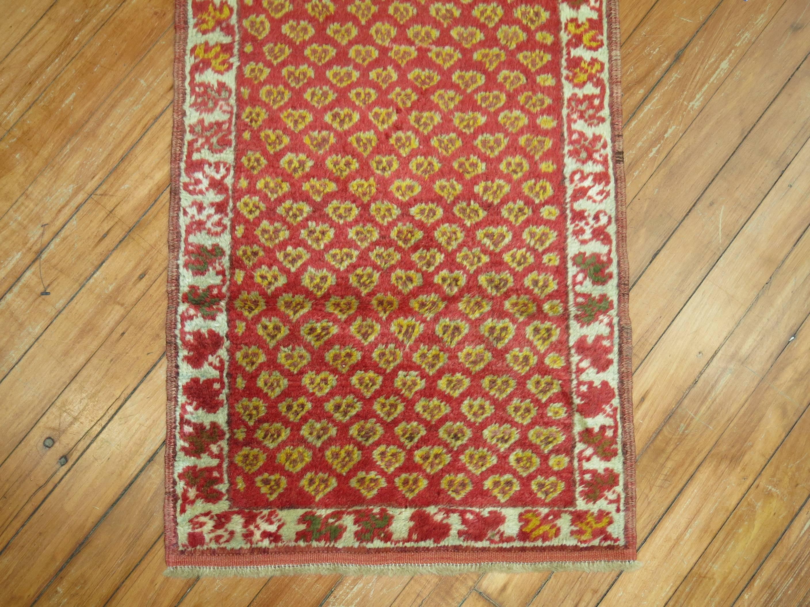 An early 20th century Turkish rug handwoven in central Anatolia. An all over floral design on a red ground and narrow ivory border

1'8'' x 3'7''