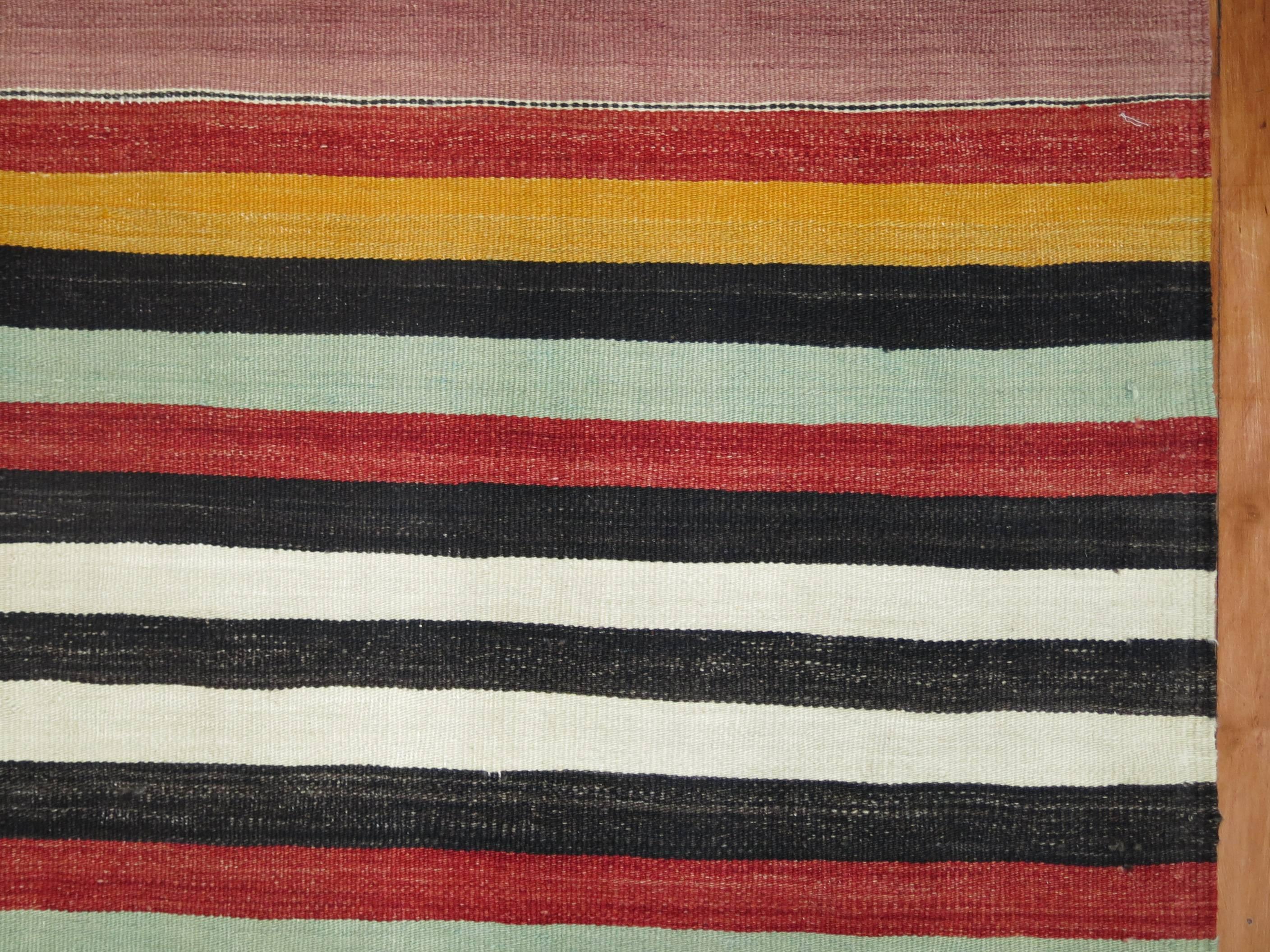 An intermediate size vintage Turkish Kilim with a colorful striped design throughout, circa mid-20th century.

Measures: 6' x 9'9