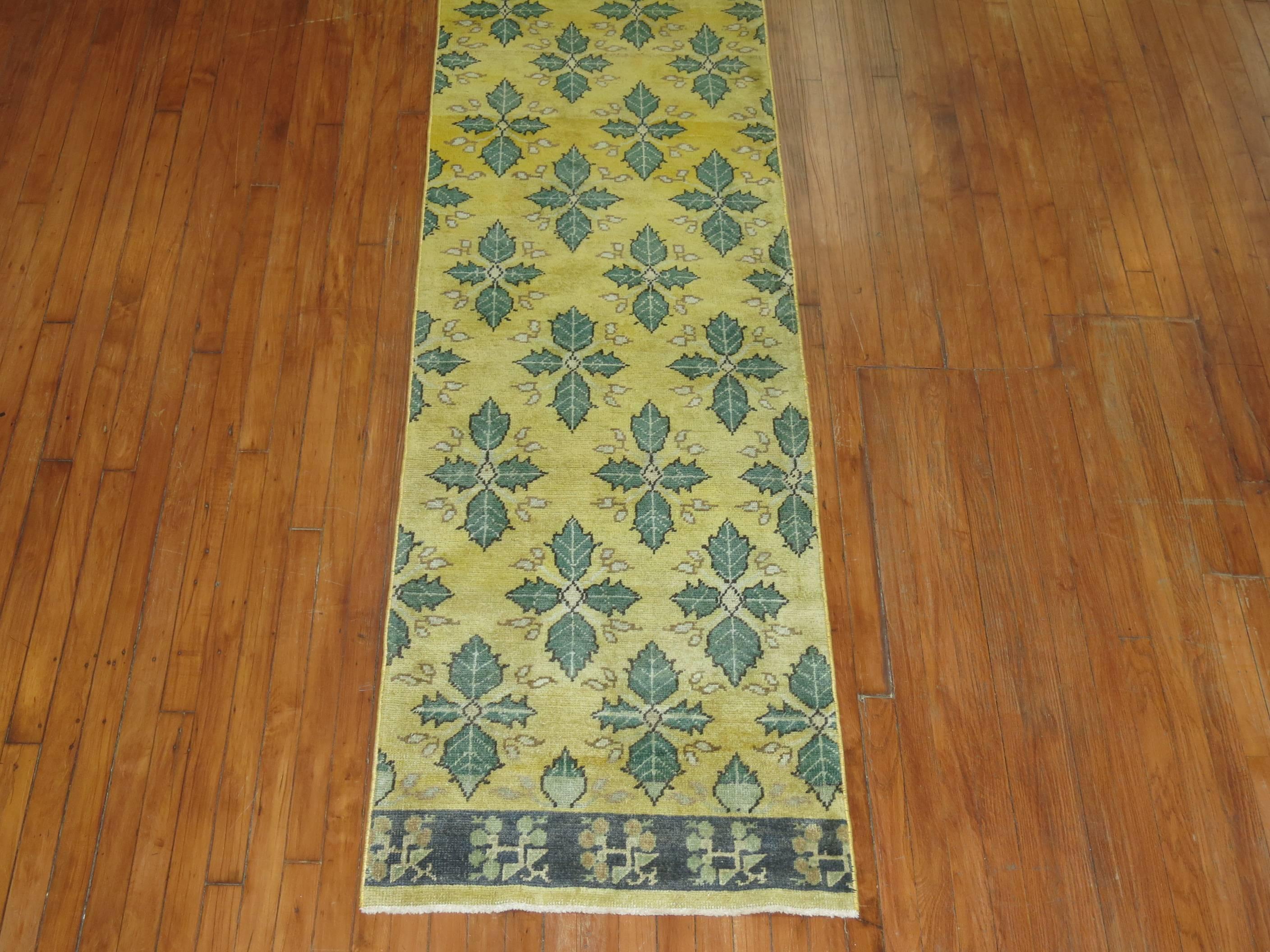 Un tapis sans bordure réalisé à partir d'un grand tapis turc vintage dans des tons prédominants de jaune et de vert.

Mesures : 2'6