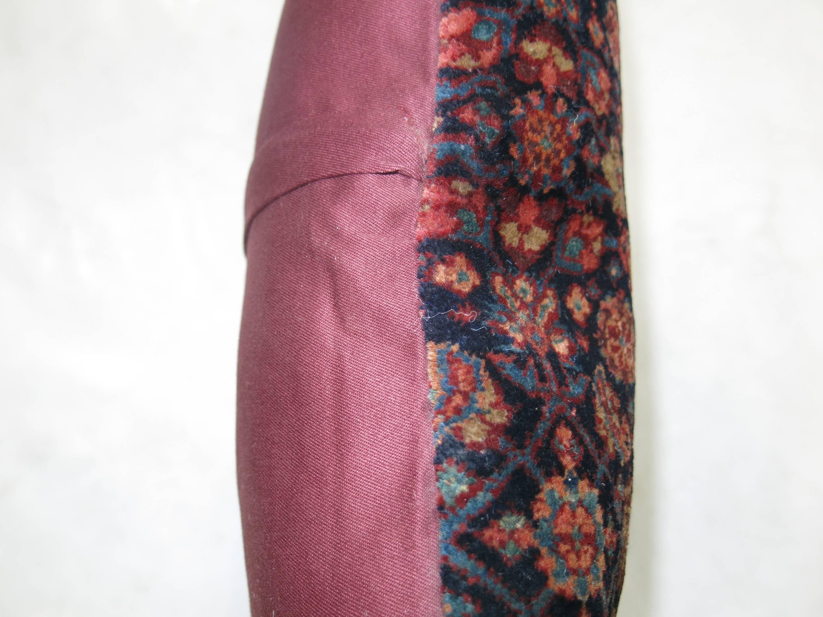Pillow made from a vintage Persian rug backed in pink cotton.