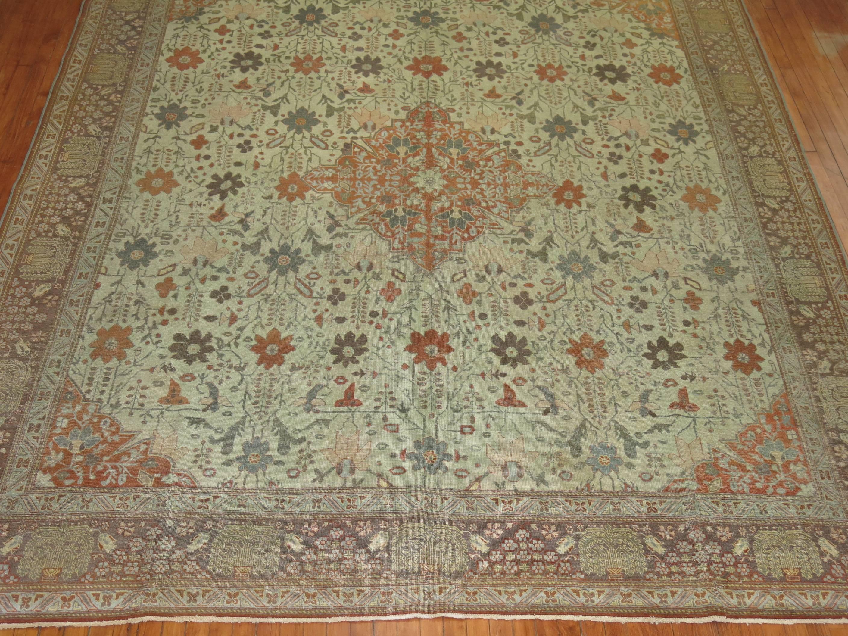 An early 20th century Persian Tabriz rug in earth tones with an autumn-like motif.