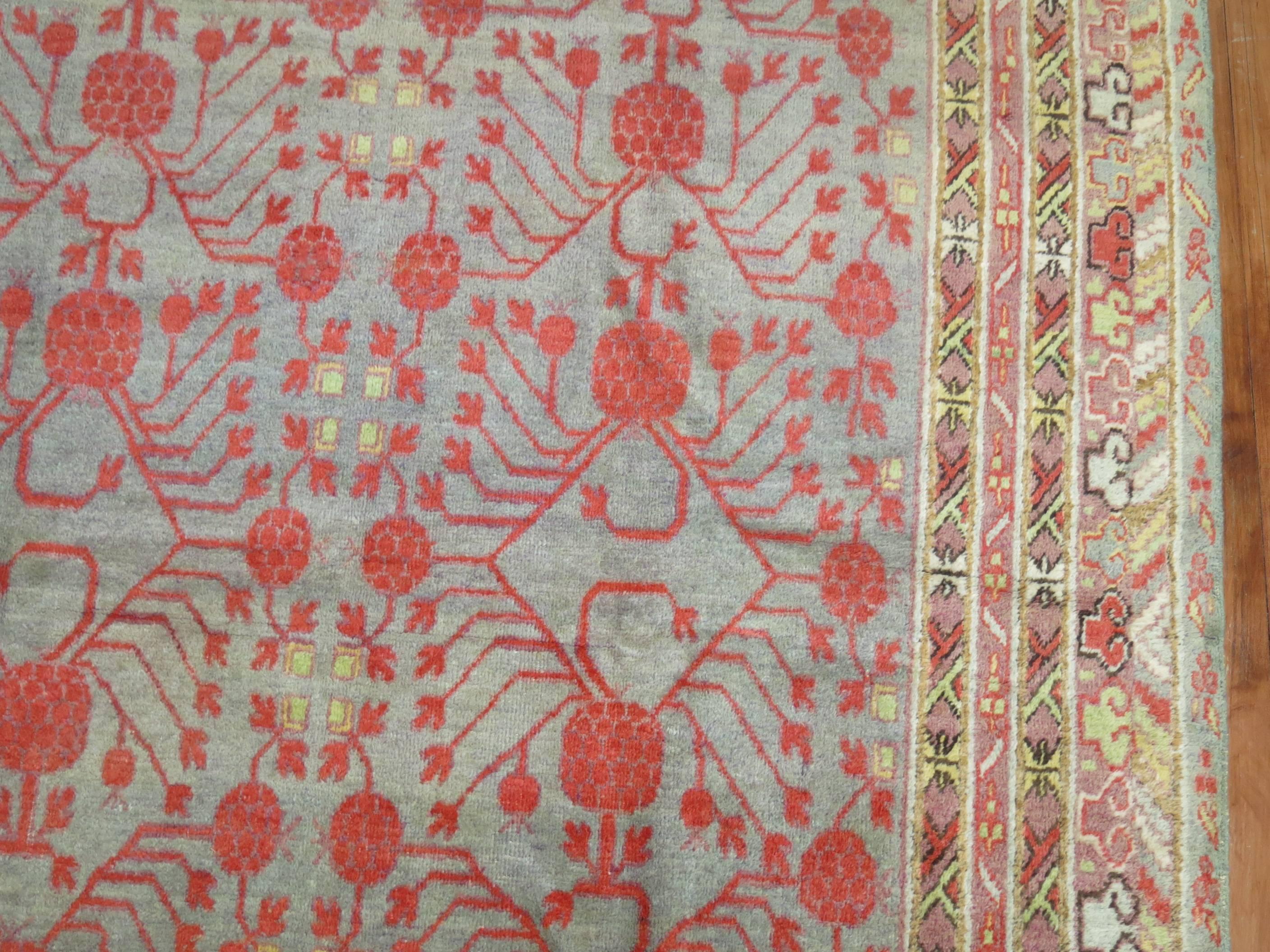 East Turkestani Wool Early 20th Century Khotan Gray Field Red Pomegranate Full Pile Rug For Sale