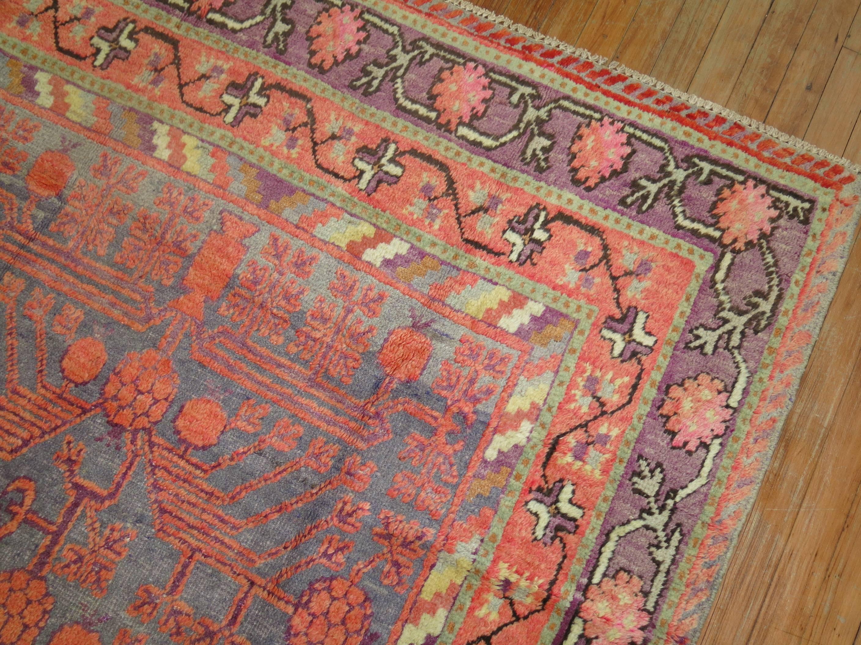 Wunderschöner Khotan-Teppich aus dem frühen 20. Jahrhundert mit klassischem Granatapfelmuster, umgeben von einer Blumenbordüre. Grauer Grund, dominante Akzente in Koralle und Lila.
Durchgehend gleichmäßiger mittlerer Flor. Dieses Stück ist nicht