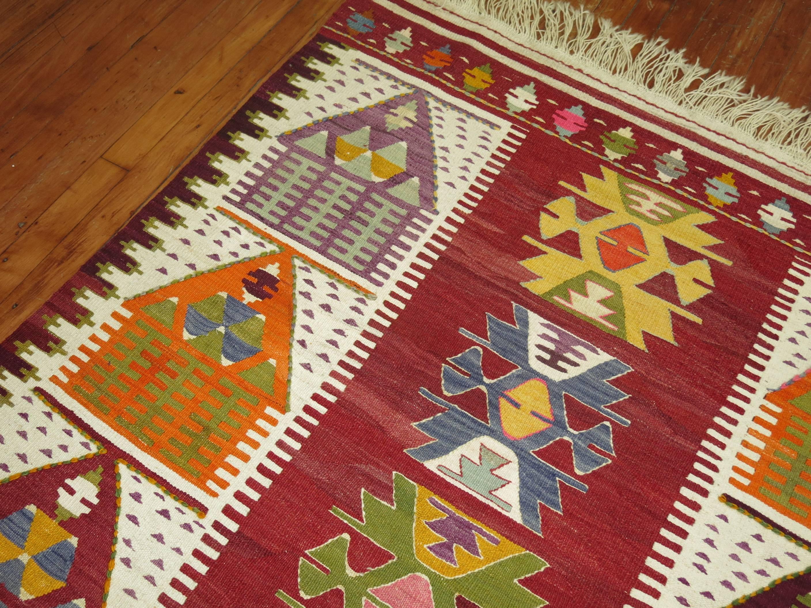 A vintage turkish Kilim flat-weave with a directional motif of small homes.
