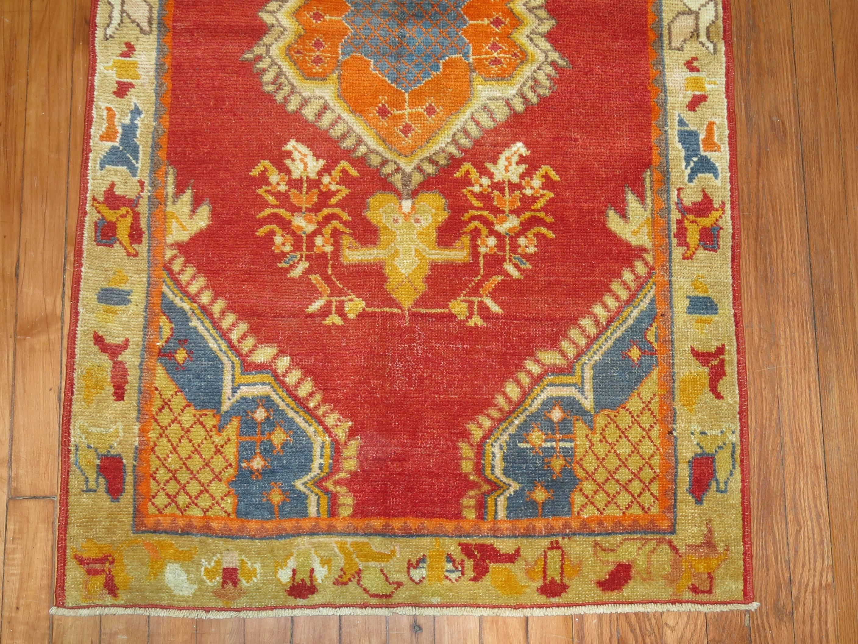 A vintage Turkish oushak rug with pumpkin orange medallion on a cheerful red field with french blue accents.