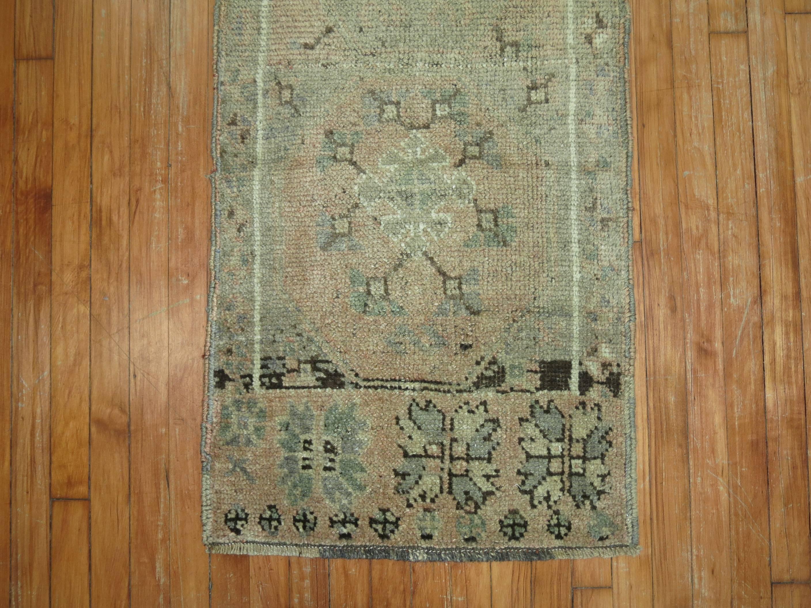An antique Turkish Oushak rug in pale colors.