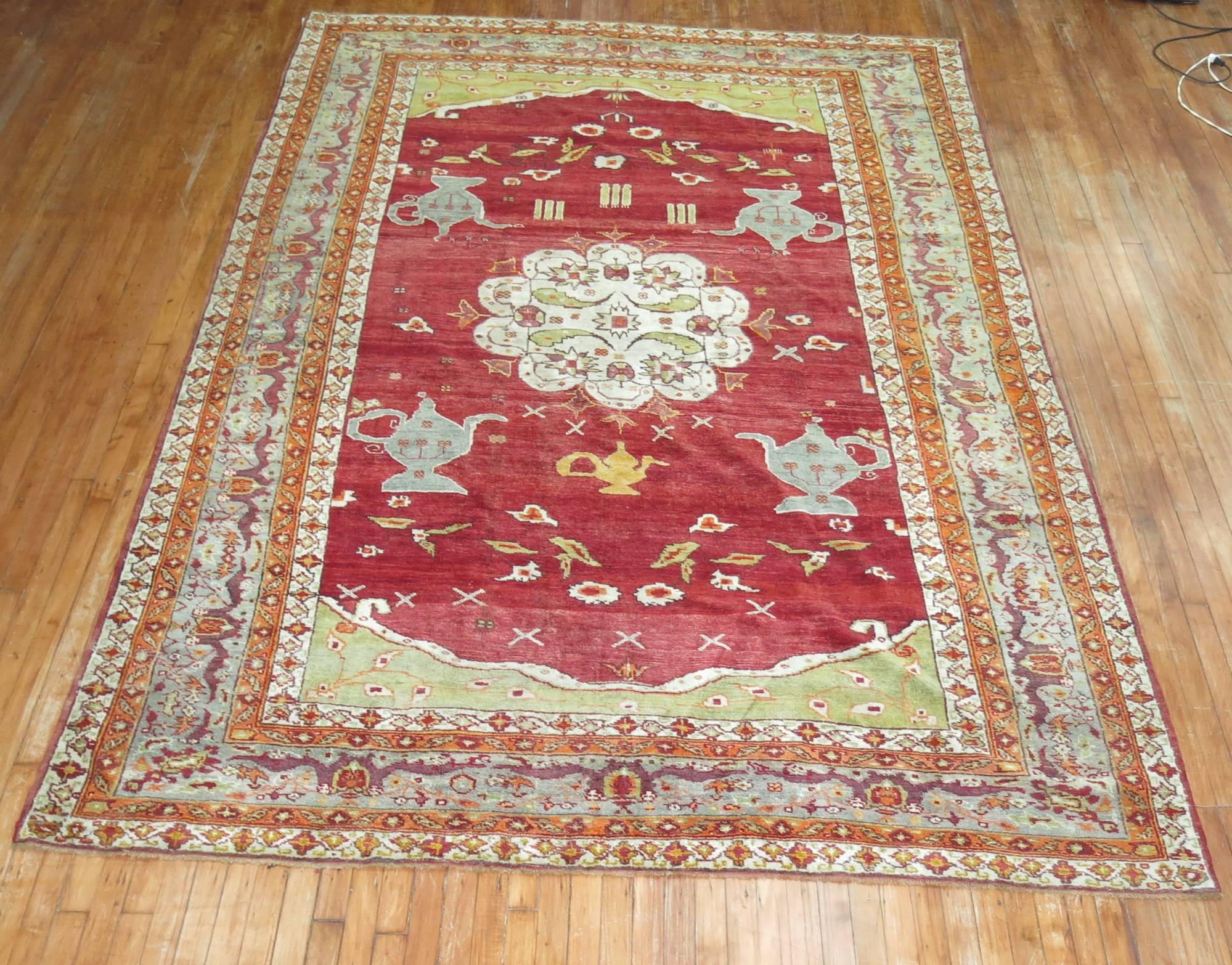 An early 20th century Turkish Oushak rug. 4 teapots on a rich cherry color field, accents in lime green, gray , and orange

Measures: 7'5