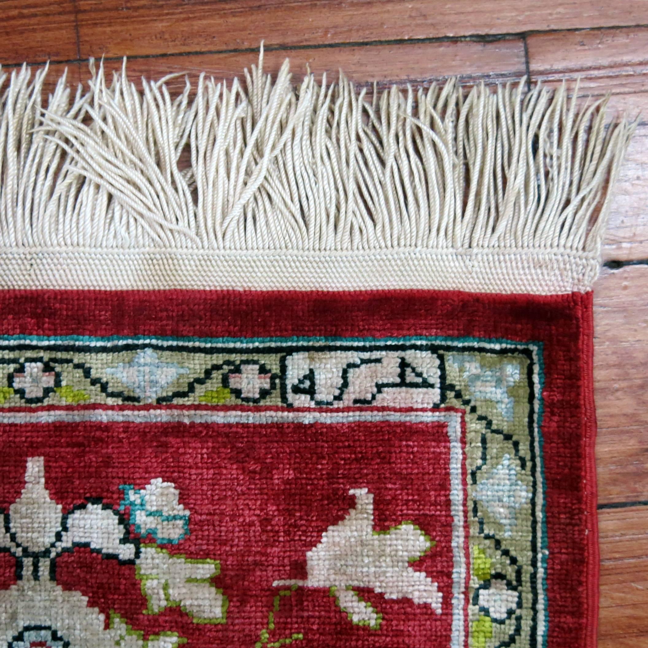 Tiny silk Turkish rug in Chinese red.

Measures: 10” x 12”.
