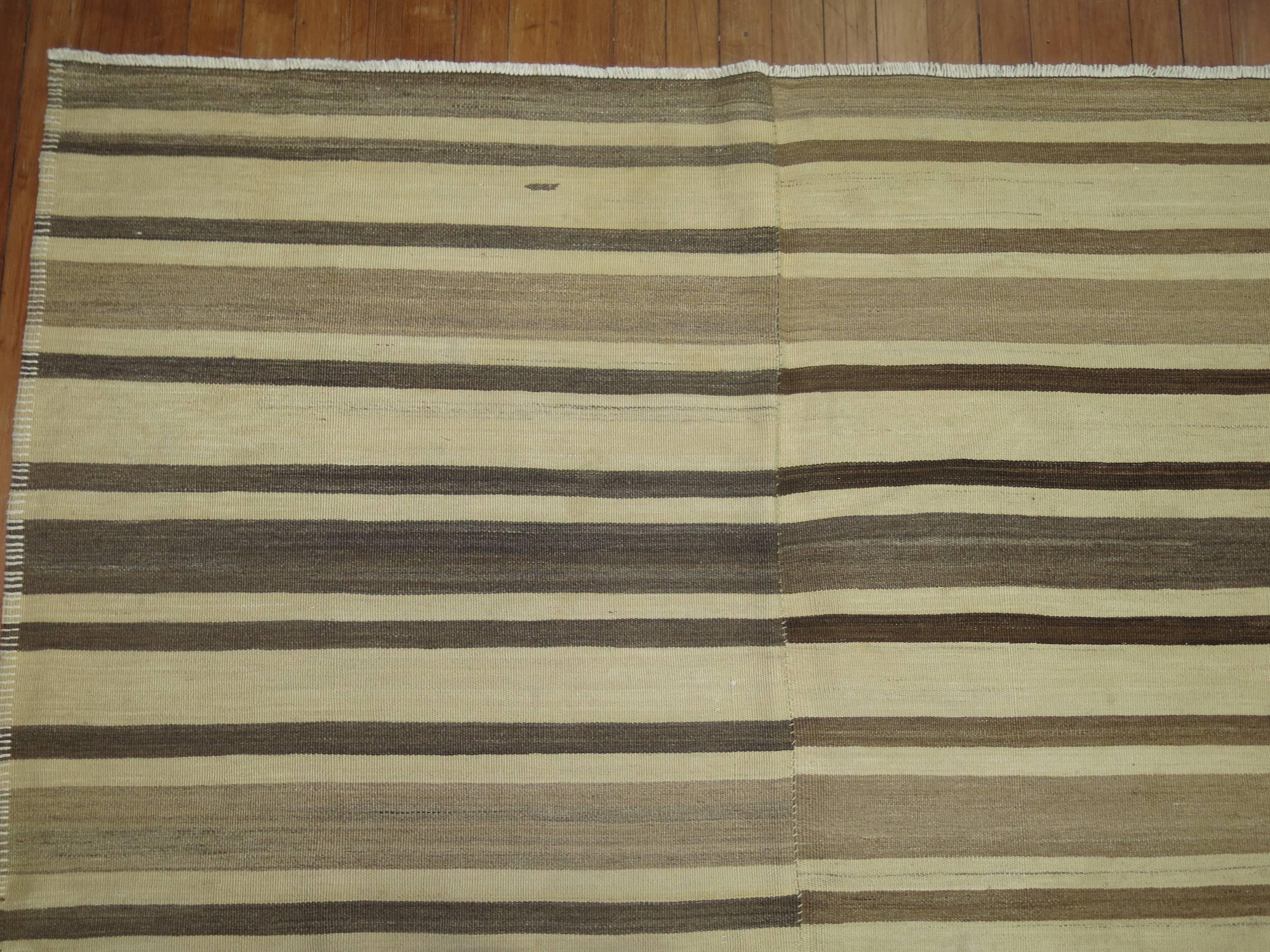 A vintage turkish kilim with a striped motif in browns and cream.

5'1'' x 9'9''