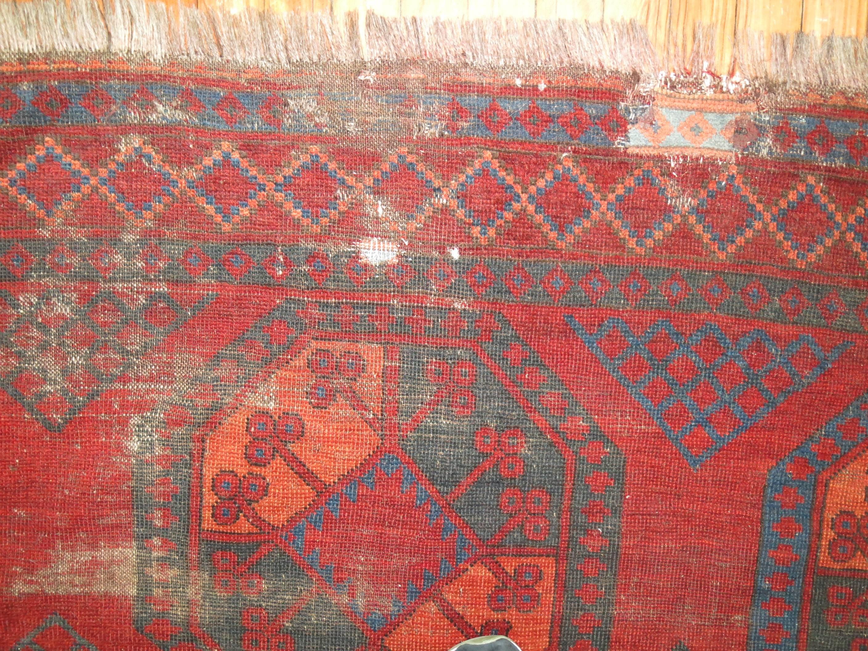 An early 20th century Shabby Chic Ersari Rug in Bright Chinese Red.

We love the  natural wear on this rug because it shows a real taste of the life that it's already lived,  Also shows it has a had a history and character which  truly makes it one