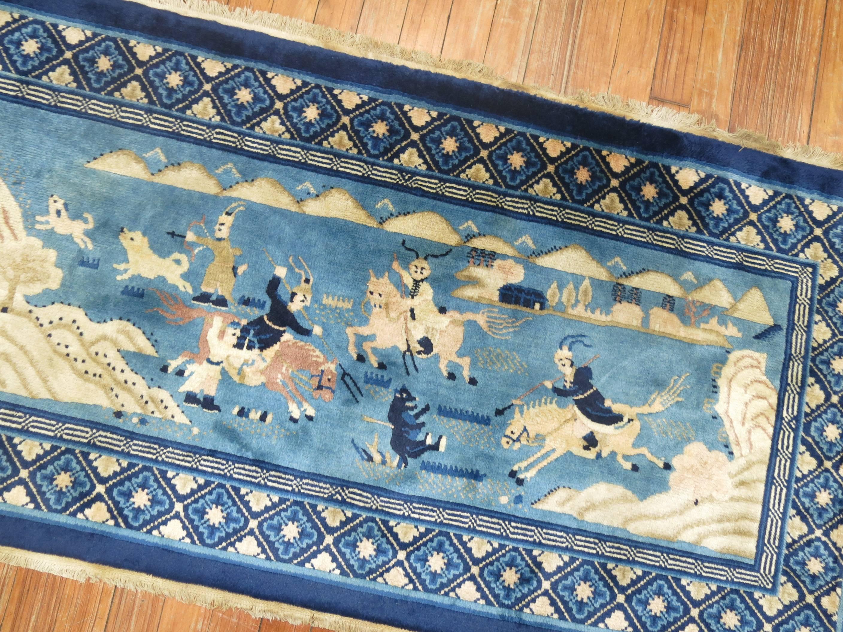 A 20th century Chinese Pictorial Hunting scene rug in vivid blues.