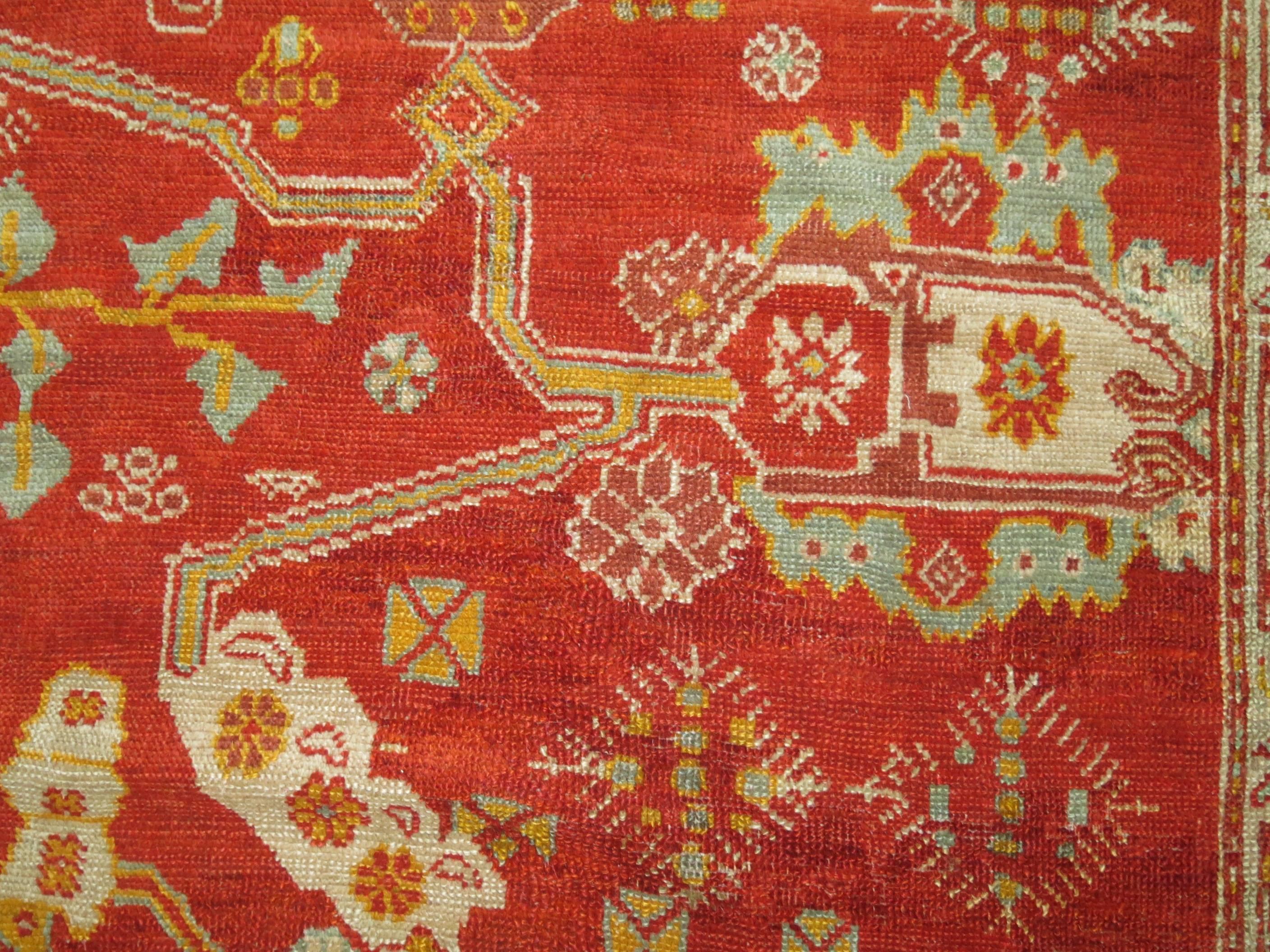 Stunning early 20th century Turkish Oushak rug woven with angora wool. Bright red field and blue-green border. Exceptional high quality.

8'2'' x 9'10''