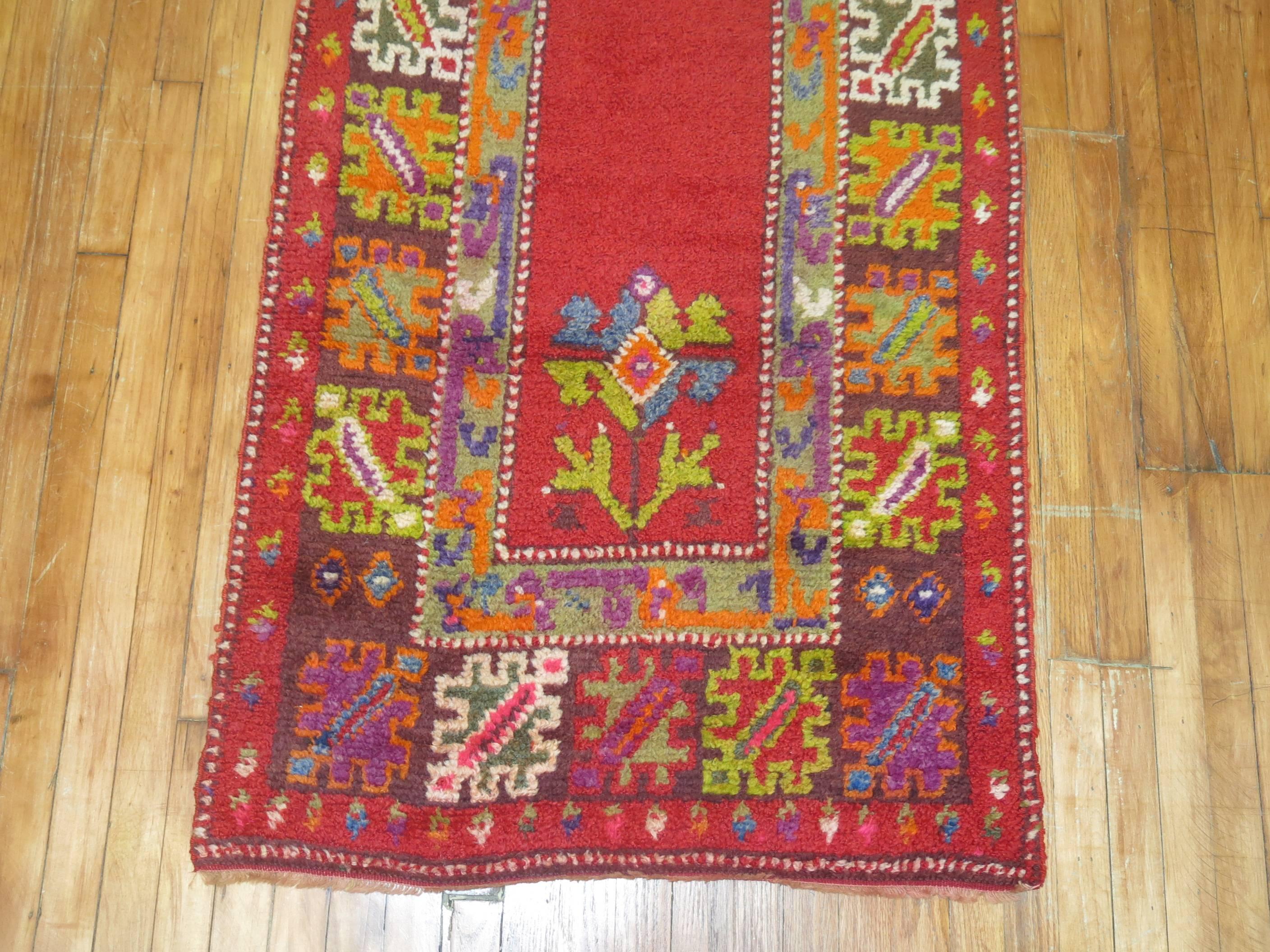 Cheerful Turkish Tulu shag runner featuring a cherry red open ground surrounded by a colorful floral border.

2'11'' x 10'9''