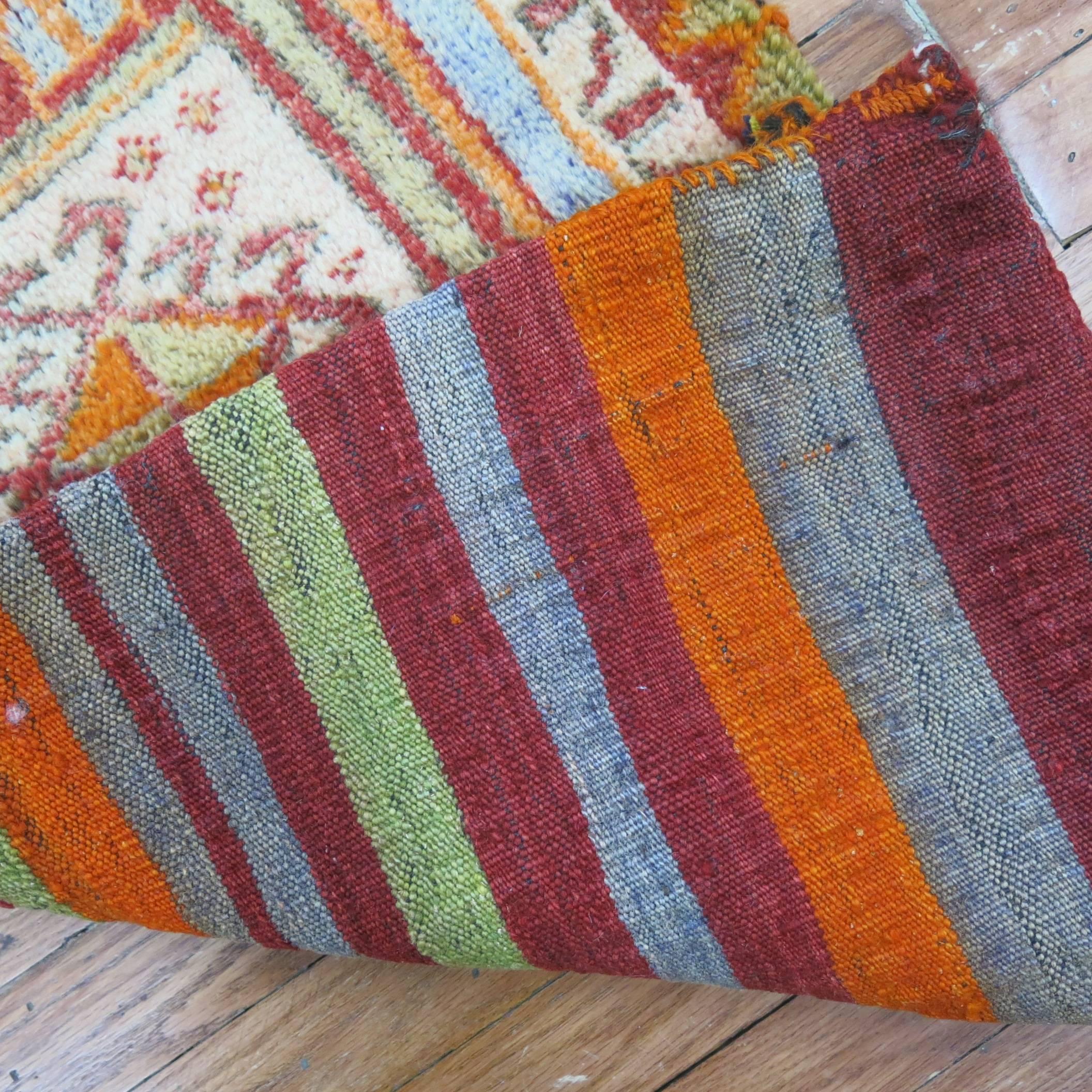 A bright Turkish yastik rug with striped Kilim back intact. One end and two sides are sewn shut while other end was kept open. Can be used as a throw piece or wall covering too.

1'9'' x 3'2''