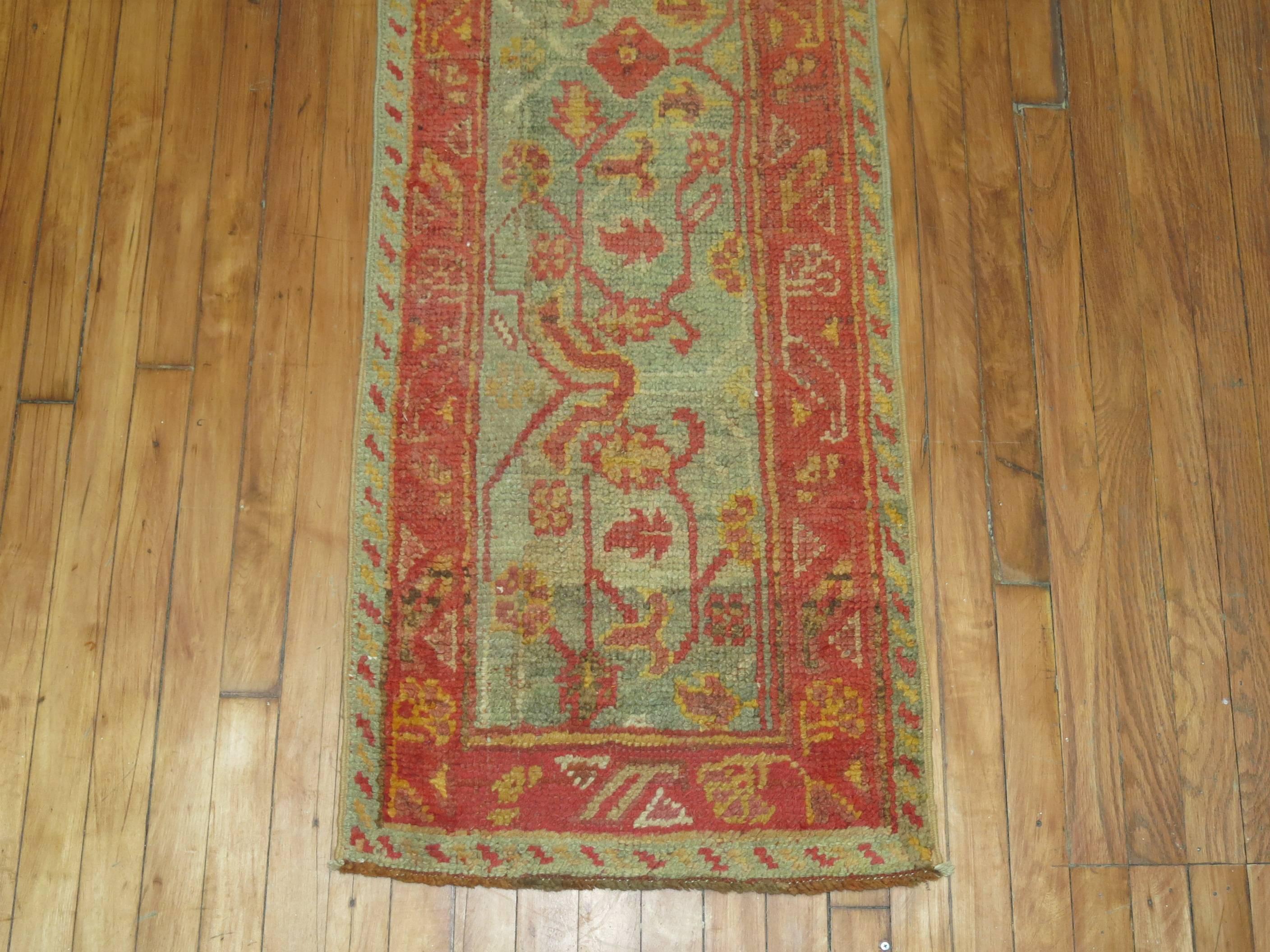 A rare size early 20th century antique Oushak runner in sage green and warm terracotta accents.

Measures: 1'9