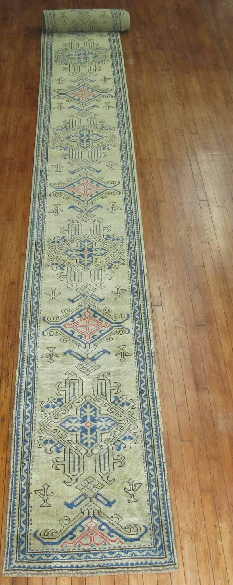 Long and narrow antique Oushak runner in blues, pinks on bone colored field. Close to 35 ft long.