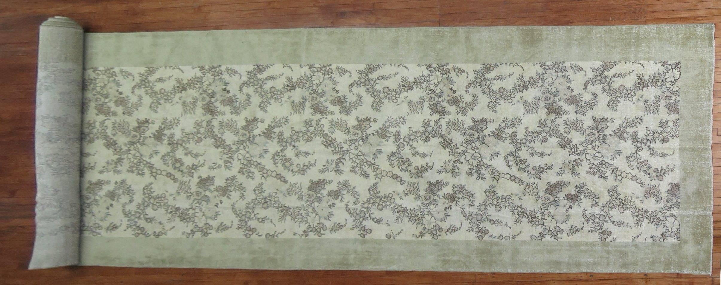 A one of a kind mid-20th century Turkish rug with an all-over floral palette with a plain soft celadon green border.