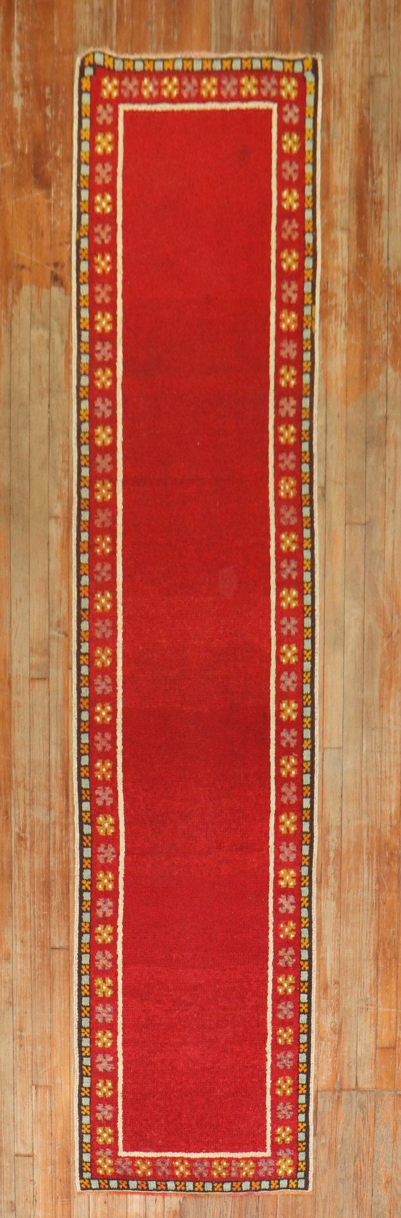 Bright red vintage Turkish Tulu runner with a plain open field design and narrow floral border.

Measures: 2'5