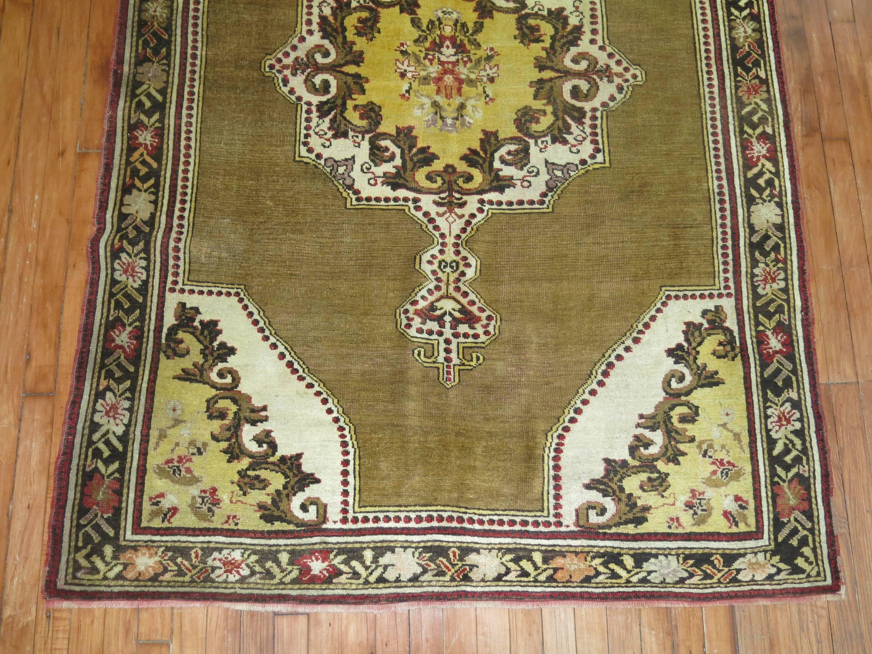 One of a kind Turkish ghiordes open field medallion rug with a rare olive green colored field, brown and yellow medallion.

Measures: 4'6