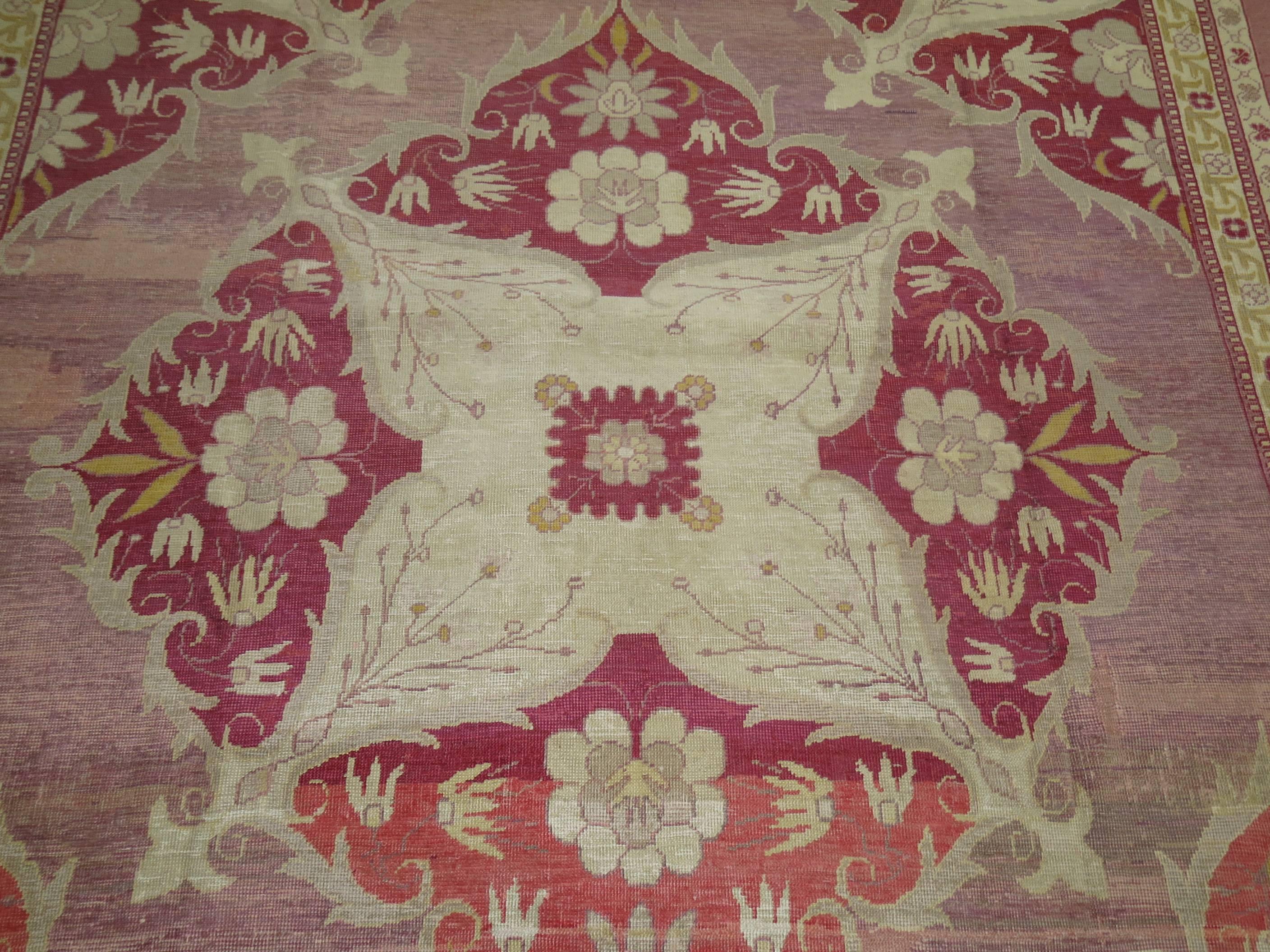 A rather unique Turkish  rug with beautiful burgundy, pink and lavender colors. The graphic and design on this rug make it even more extraordinary.  In the early 19th century, on the outskirts of Istanbul, the Hereke carpet workshop was established,