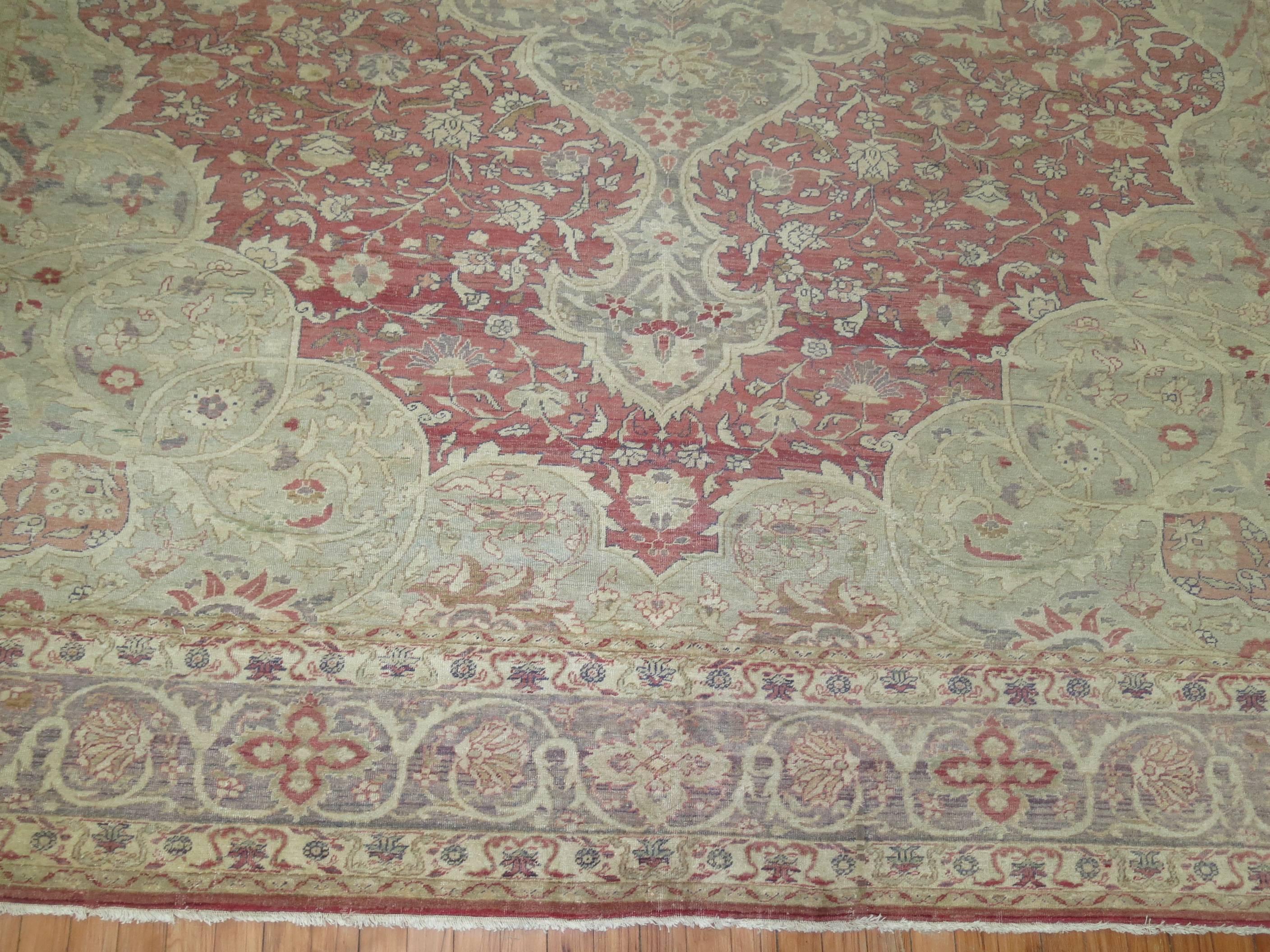 A late 19th century formal Turkish Sivas rug with a rosy red background, silver medallion and silver border. Other accent colors terracotta and celadon. The quality is superfine and the pile on the rug is extremely thin. One of the finer woven