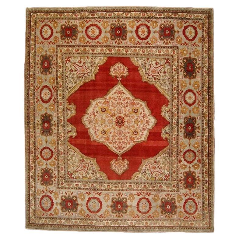 A magnificent square shaped formal antique Turkish rug containing a pretty array of jewel tones, an isolated central medallion and an amazing wide border. The border is almost 30 inches wide and long on each side. Woven with amazing precision and