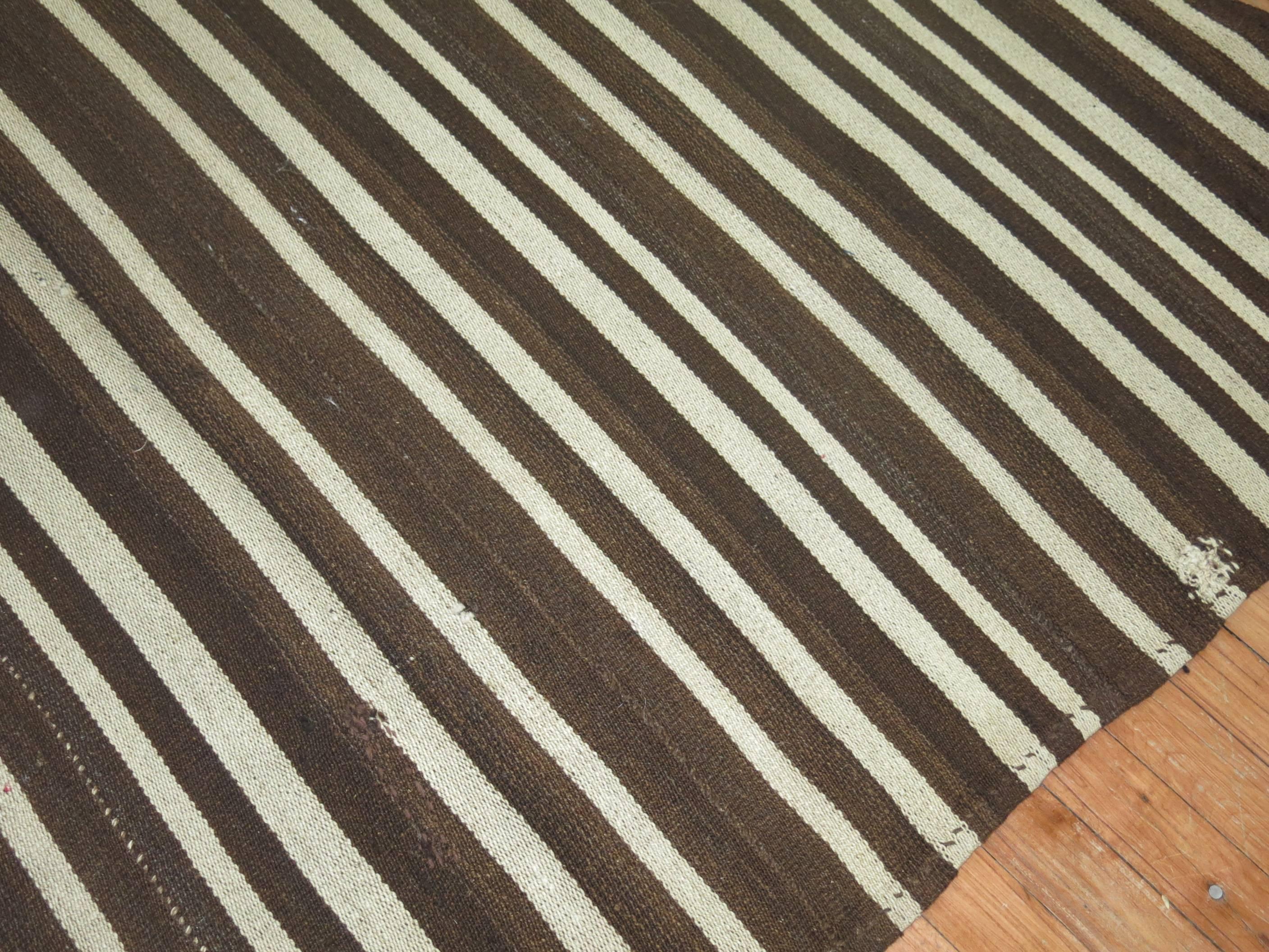 A rugged striped Kilim woven in Turkey. Chocolate brown and creams.

Measures: 6'3