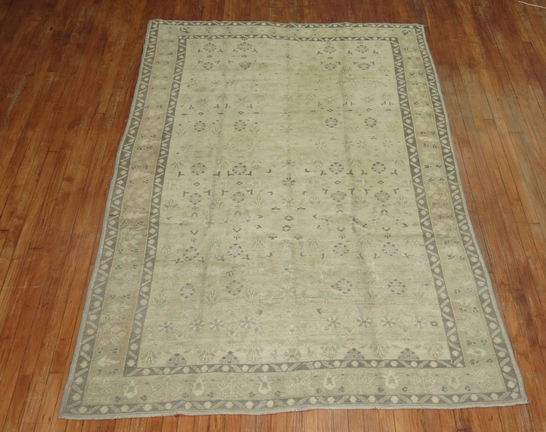 A vintage Turkish Oushak rug. Beige ground with a border containing multiple shades of browns and camel. There is some soft greens and lavender as well, circa 1940.

Measures: 5'9