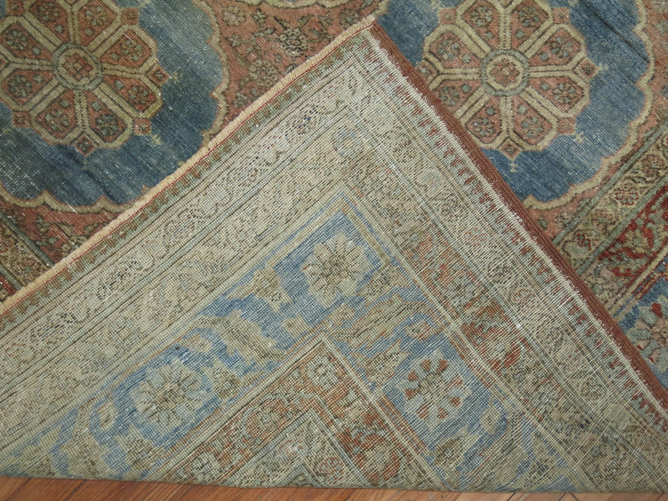 An unusual Northwest Persian carpet featuring soft blue circular motifs on a burnt orange ground and multi band border. We have never seen one in this size.