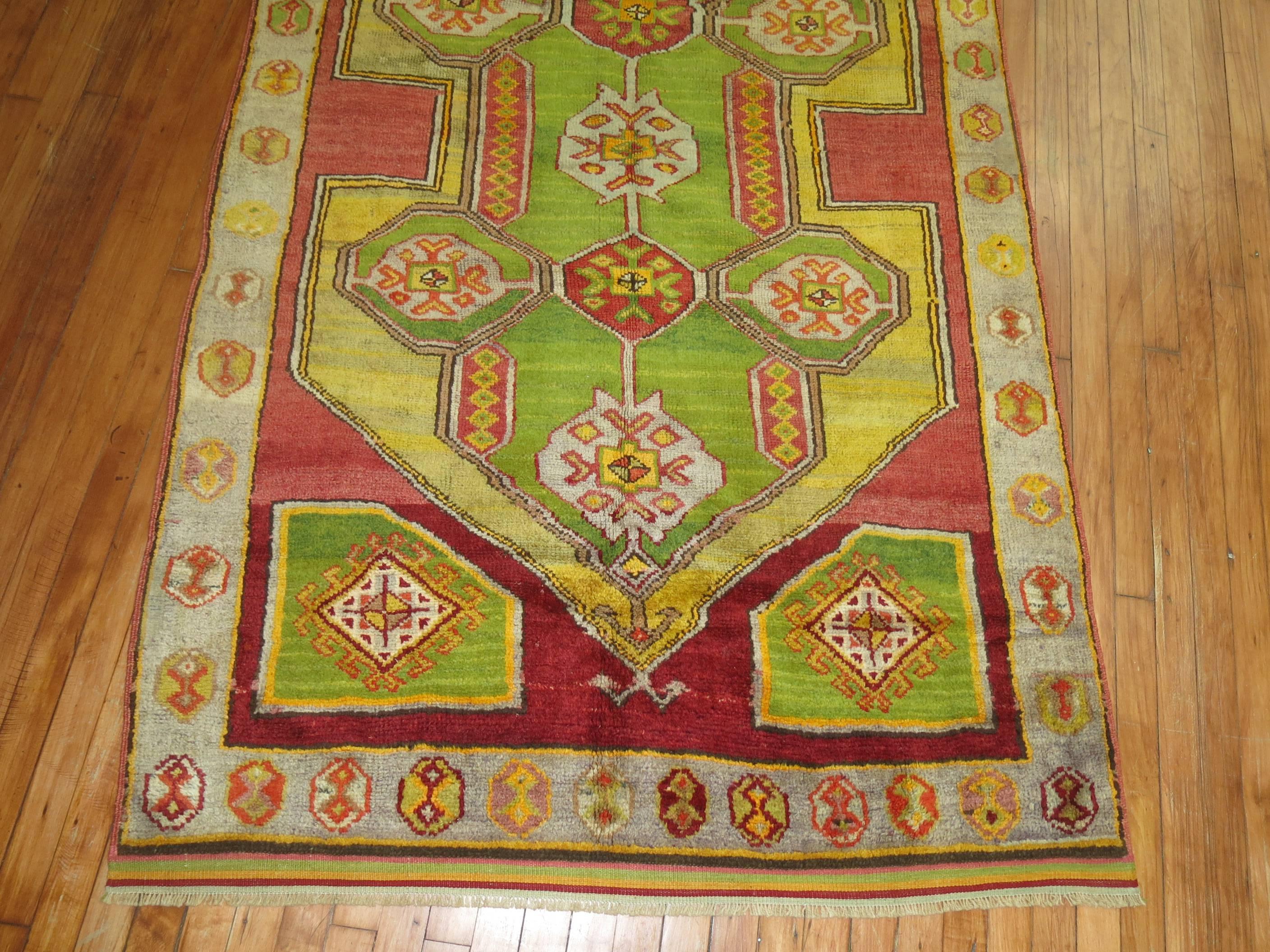 A mid 20th cenutry Turkish Konya rug featuring a bright apple green color. The medallion is a mustard, the ground is red and a gray border

4'4'' x 7'2''