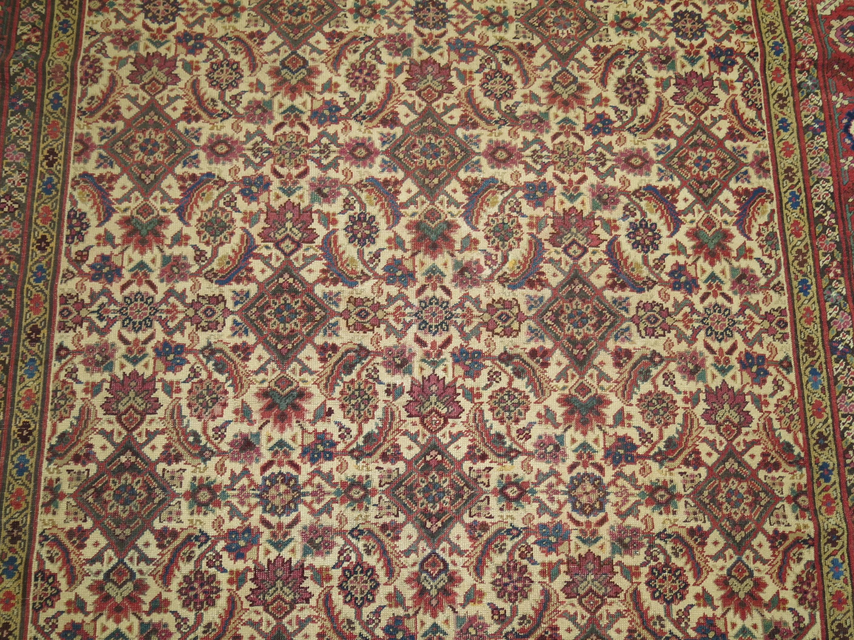 Emboldened by a symphonic palette of rarely found tones, this memorable 100-year-old gallery/corridor size antique Persian carpet from the prized Bakshaish weaving tradition demonstrates an irrepressibly energetic artistry. A riveting symphony of