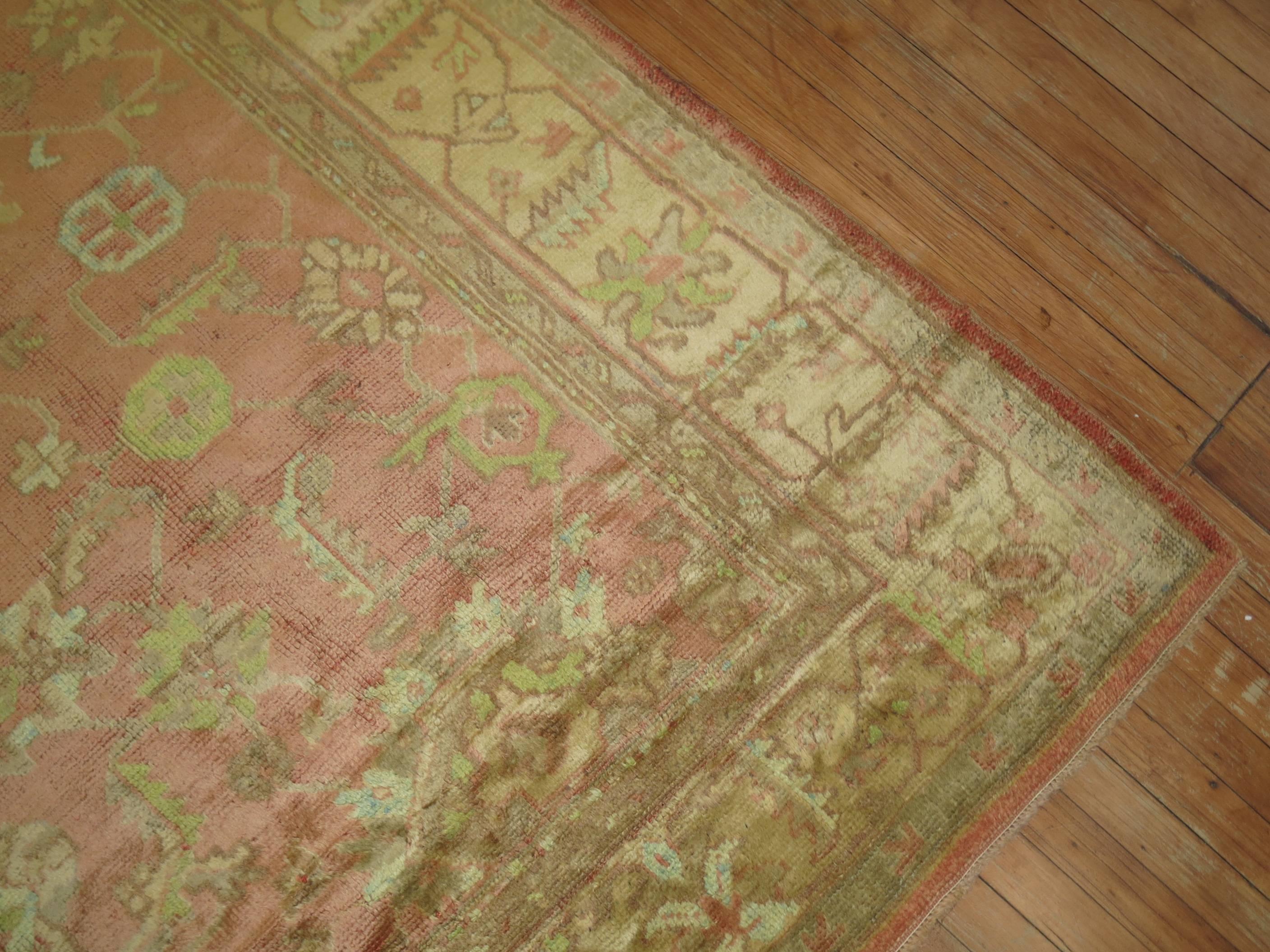 A handmade antique Turkish Oushak in pinks, peach, creams and lime green with a silky sheen and texture.

Measures: 7'6