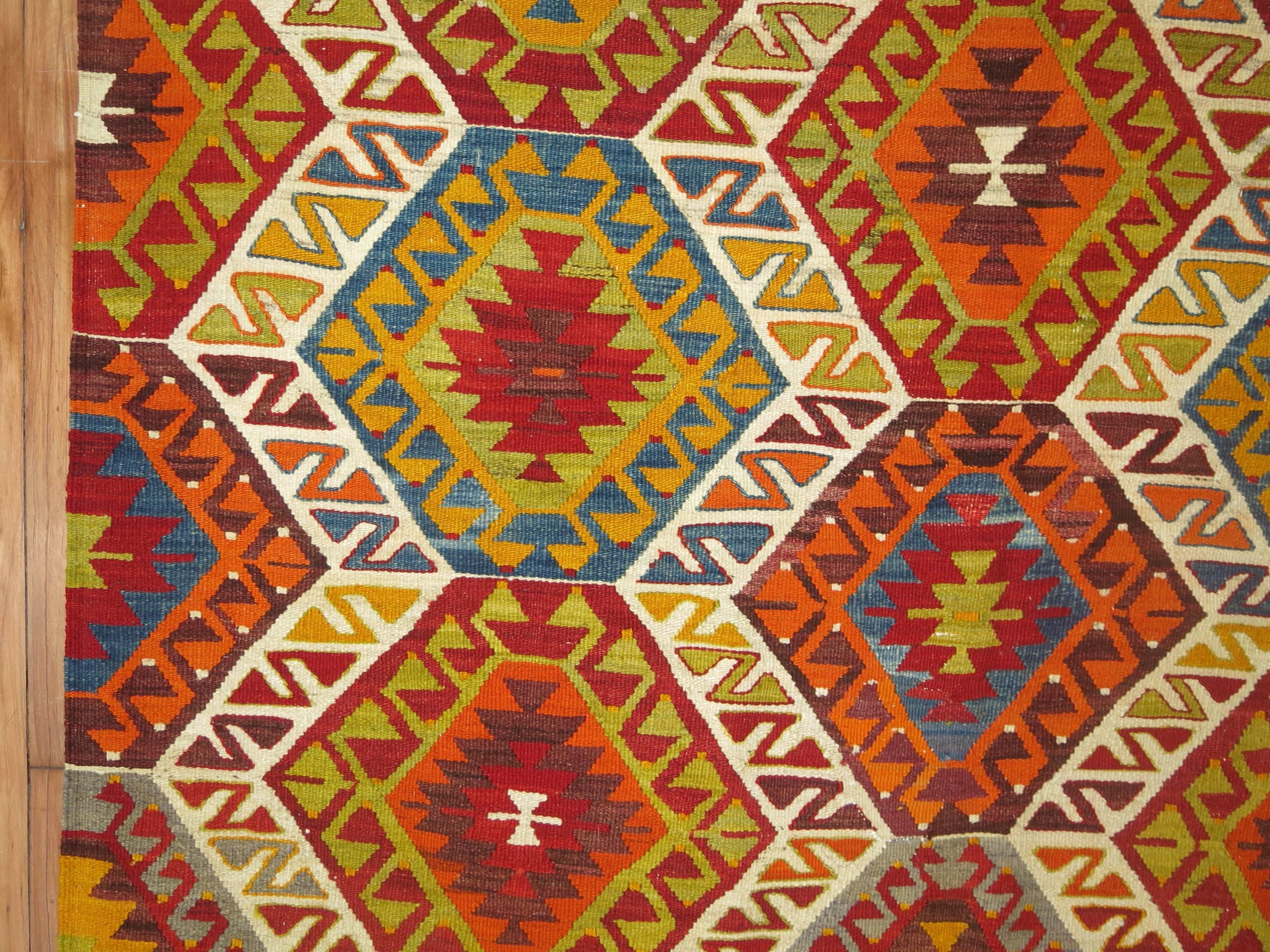 Colorful vintage Turkish Kilim flat-weave from the mid-20th century. Cherry red, chartreuse, and orange dominant accents on a ivory ground,

circa 1940, measures: 5'8
