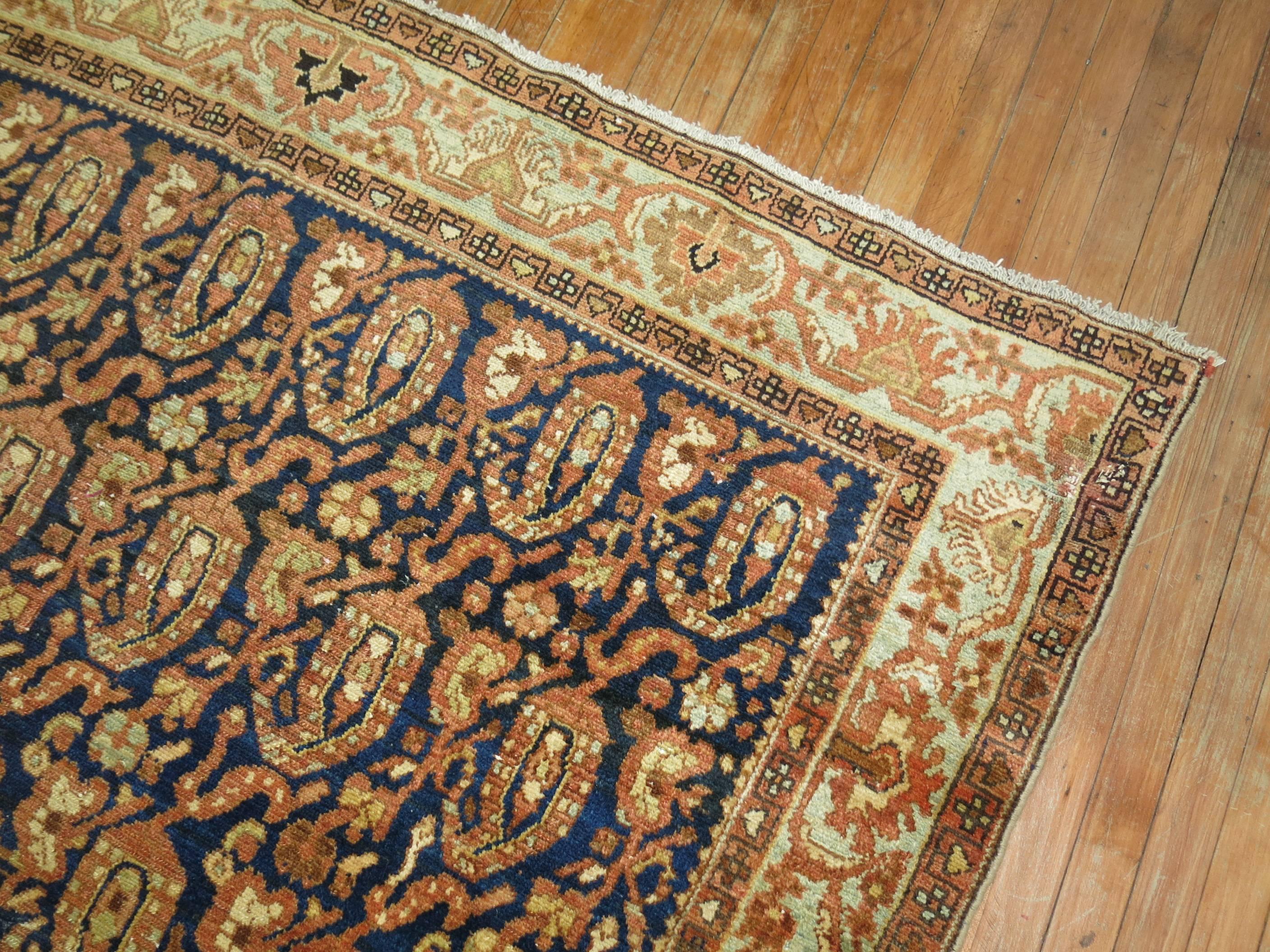 A Persian Malayer gallery rug featured a large-scale all-over paisley design in blues and terracotta, circa 1920.

Measures: 6'7'' x 13'6''.