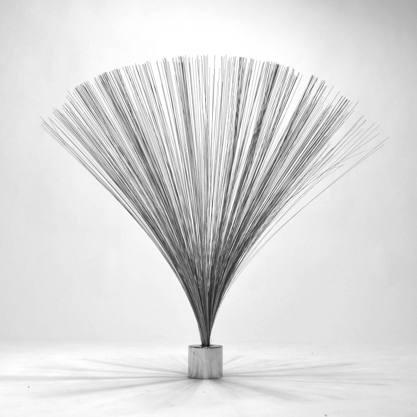 Clearly inspired by the form made famous by Harry Bertoia, this spray-shaped Kinetic sculpture is made of fine wires which can swing and sway in a soothing manner. The piece is marked with a label on the bottom of the base.