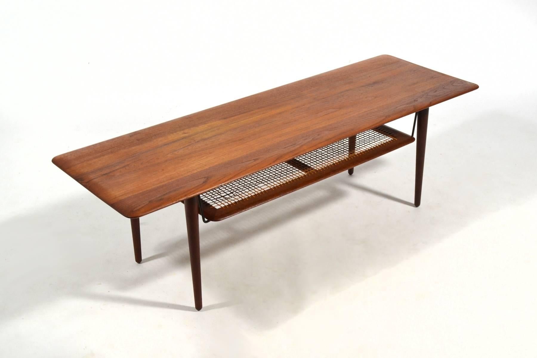 This beautiful model fd516 coffee table by Peter Hvidt & Orla Mølgaard Nielsen was designed in 1956 and is crafted of solid teak. Typical of the best Danish modern design, the excellent craftsmanship matches the refined details such as the tapered