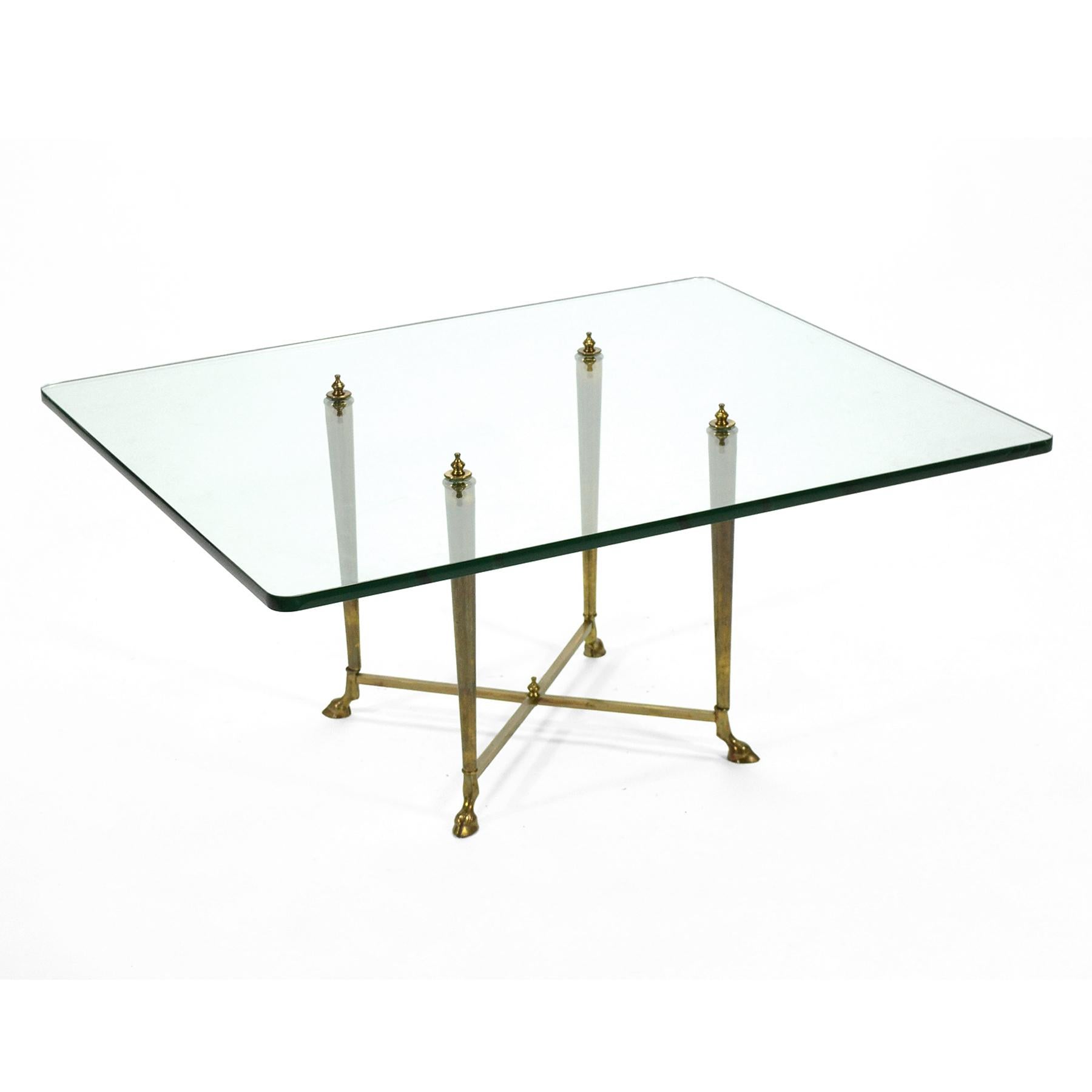 This very striking cocktail table has a base of solid brass with hoof feet that pierces and supports the glass top. Light, slender, and well engineered, it is a great example of Italian design.