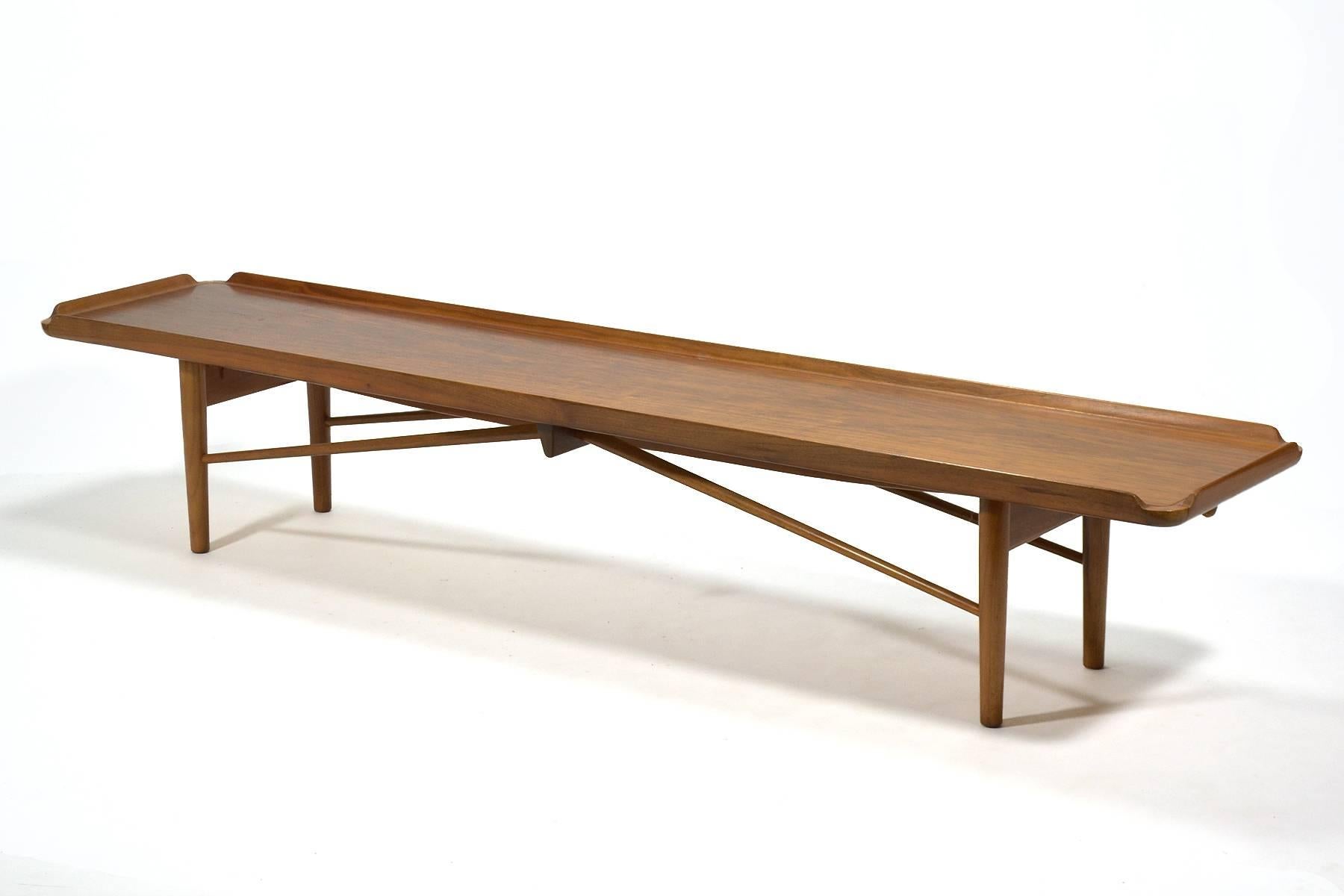 This bench by Finn Juhl was created to serve double duty. It is a long, elegant coffee table and with the addition of a seat cushion, a comfortable bench. Designed in 1951 for Baker furniture, it predates the more widely seen bench Juhl designed for