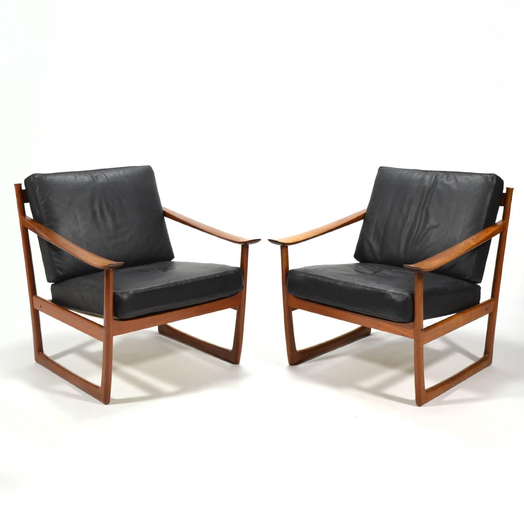 This beautiful pair of model FD 130 lounge chairs by Peter Hvidt & Orla Mølgaard Nielsen are crafted of solid teak and have several wonderful design details. The sled base is stabile on any floor, and the broad, flared arms feel wonderful in your