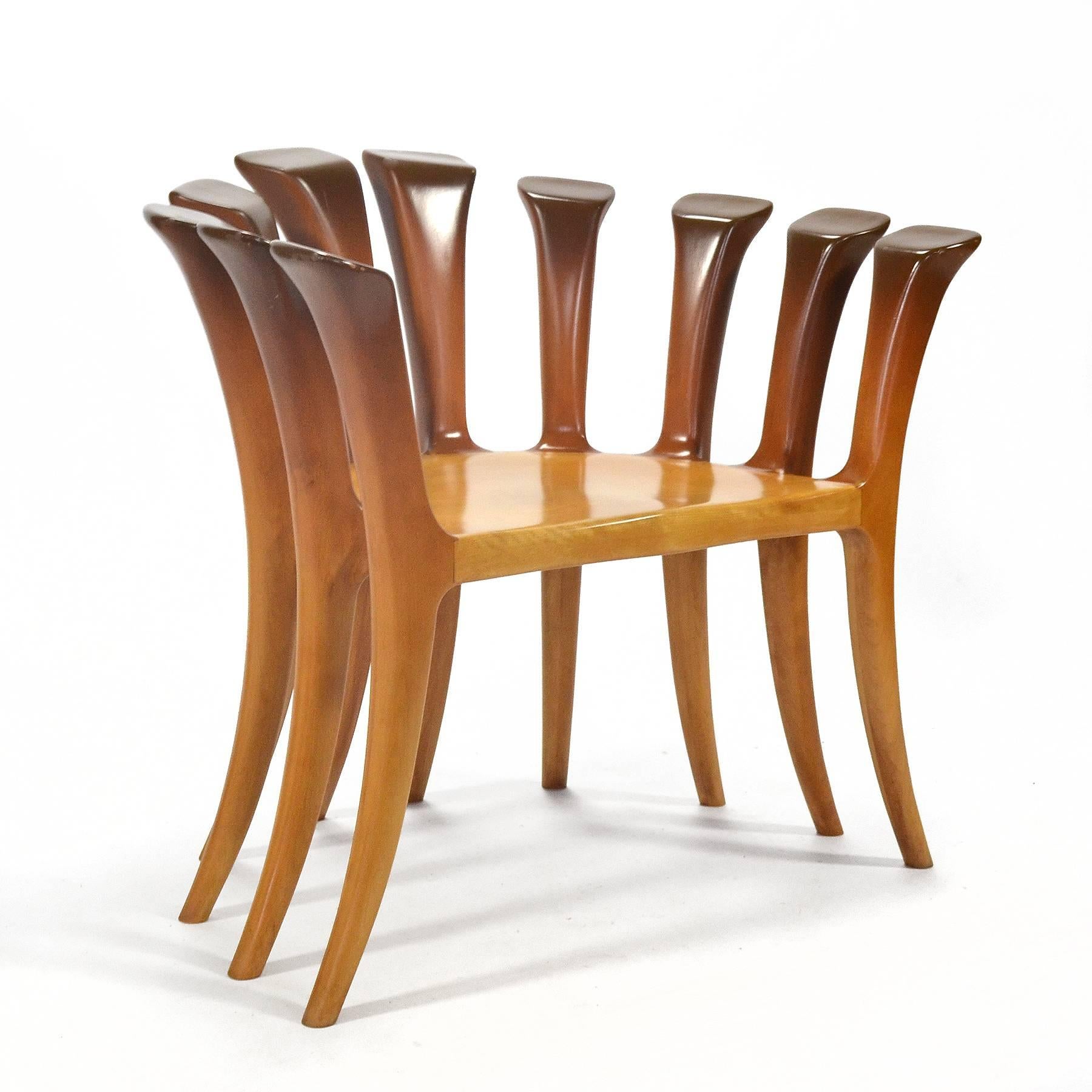 This incredibly well designed and well crafted chair is a powerful statement piece. With ten legs that curve and flare as they move upwards to suspend the seat as they form the back and arms. Sadly, it is unsigned and we do not know the artist who