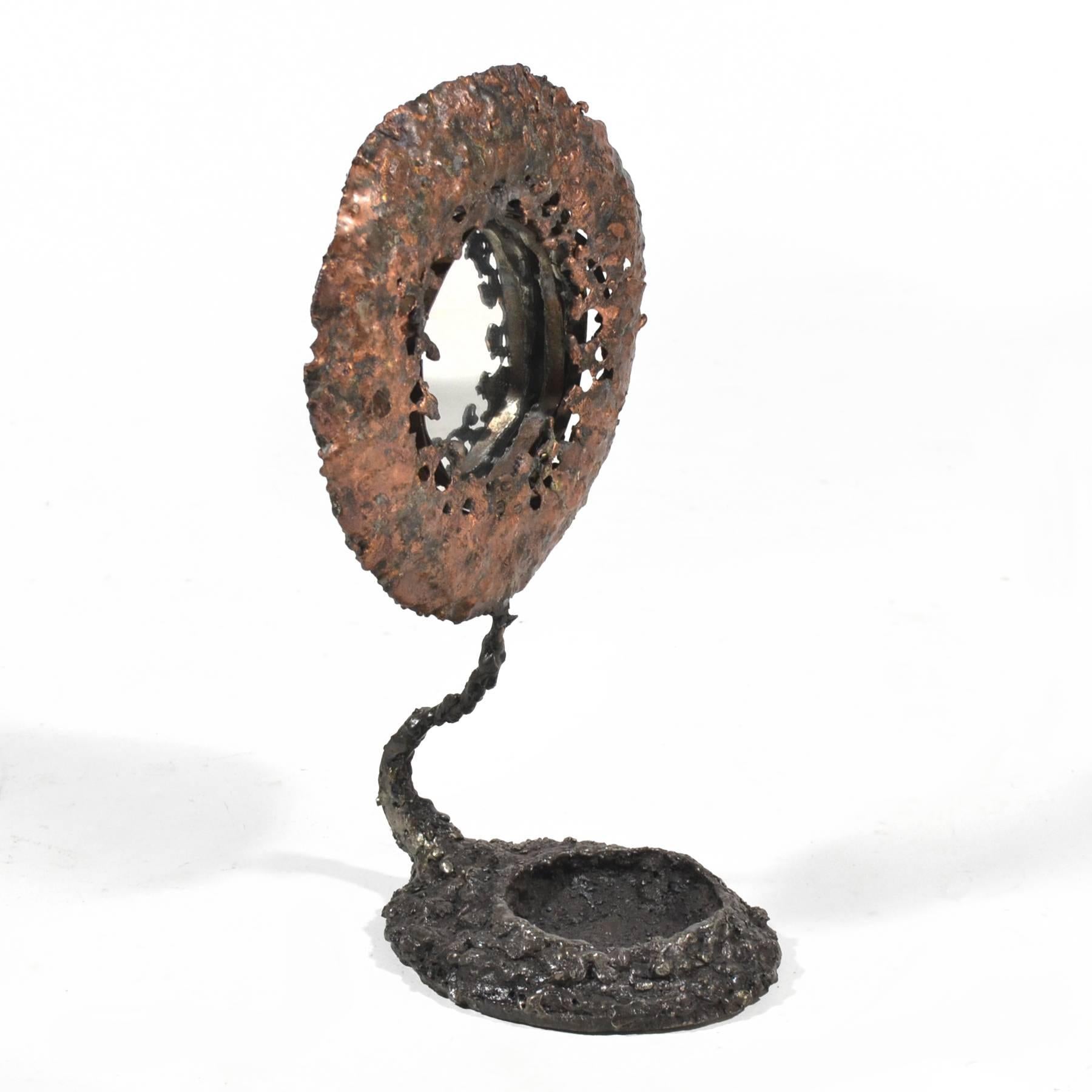 The sculptures of James Bearden are stylistically varied, but always sophisticated and visually complex. Most recently he has begun to experiment with functional works such as lamps/ lighting, case goods, and mirrors such as this one. A sculpture