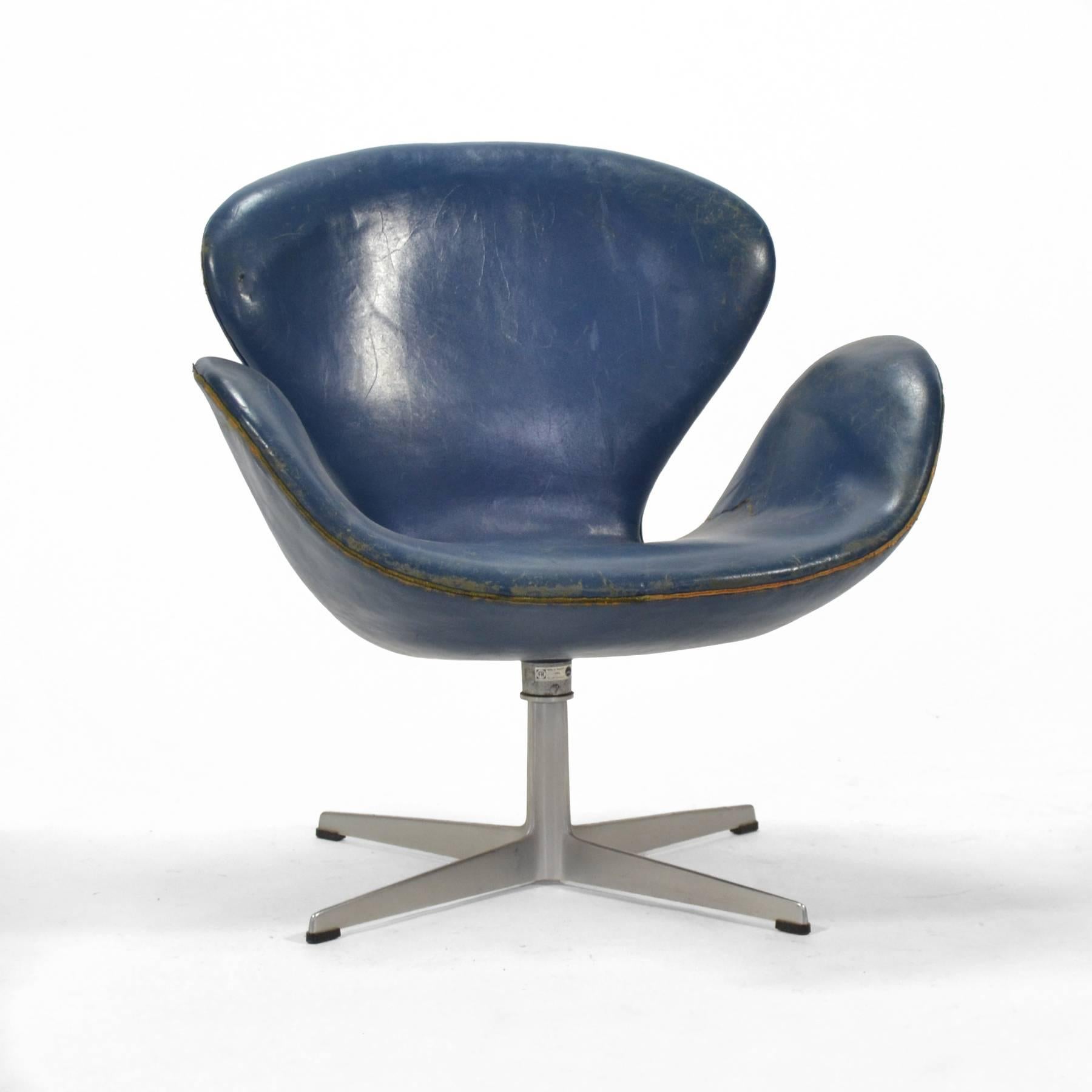 This early Jacobsen swan chair is for the collector who appreciates the original blue leather and the wear of a lifetime of use.
The heavily patinated upholstery has lots of character and a couple of rips which we are having stabilized by a