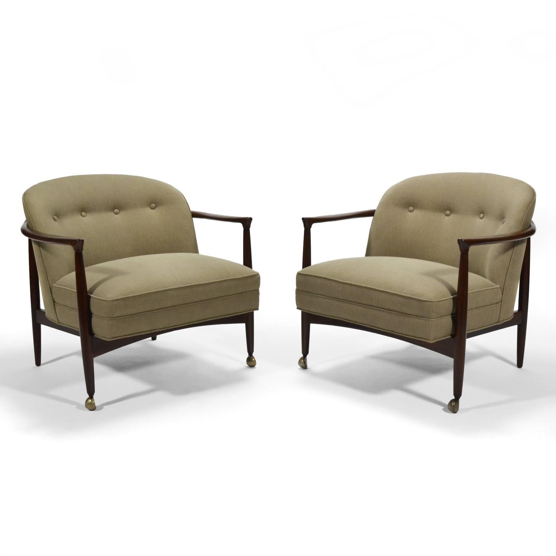 This design by finn Andersen features refined details and an exposed wood frame with lovely sculptural details supporting an upholstered seat. It references barrel-back club chairs and has casters under the front legs which is a detail that Edward