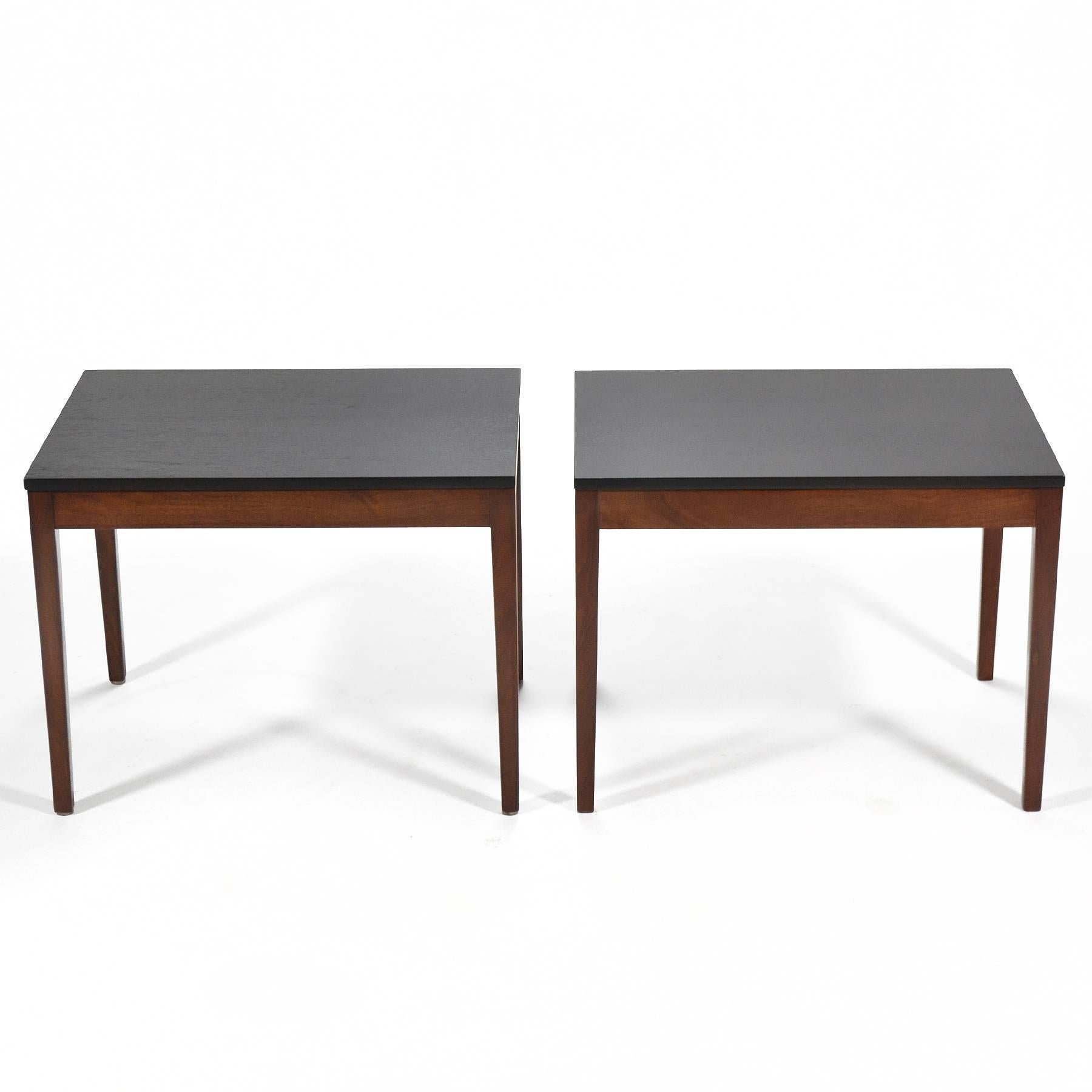 This very clean-lined pair of side or end tables by George Nelson are walnut with ebonized tops. They are typical of Nelson's rational design sensibility. Newly refinished, they are ready to use.