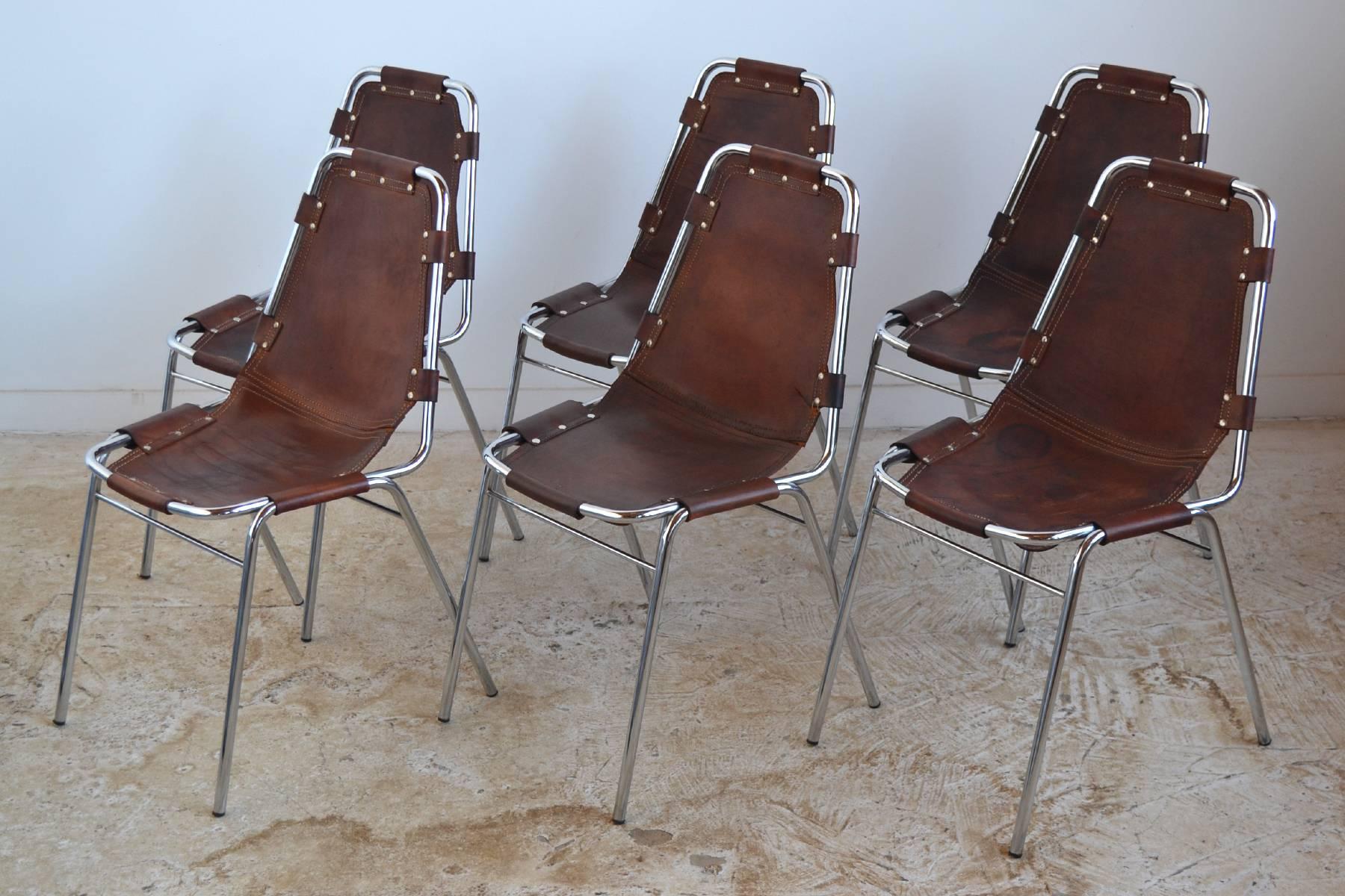 Specified for Charlotte Perriand's Les Arcs ski resort, these stacking chairs feature a chromed steel frame with a leather sling seat. The leather has acquired a beautiful patina from years of age and use.