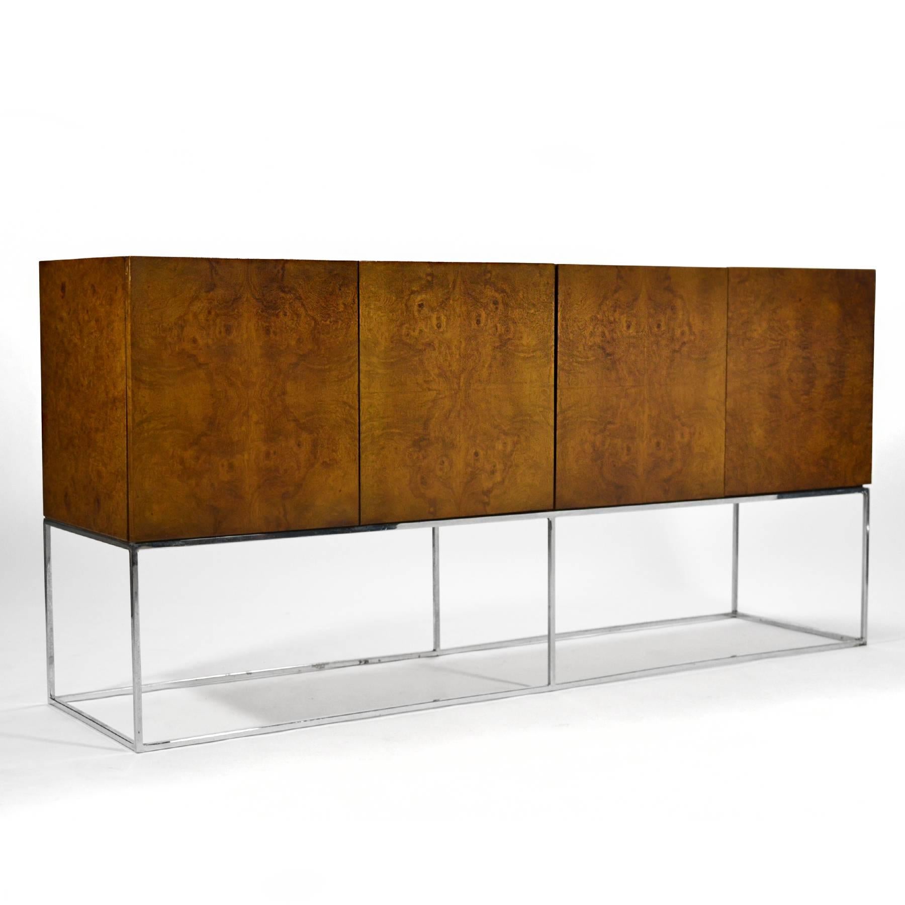 Perched on the chrome architectural base, this Milo Baughman credenza by Thayer Coggin has a great minimalist design paired with highly figured olive ash burl wood.