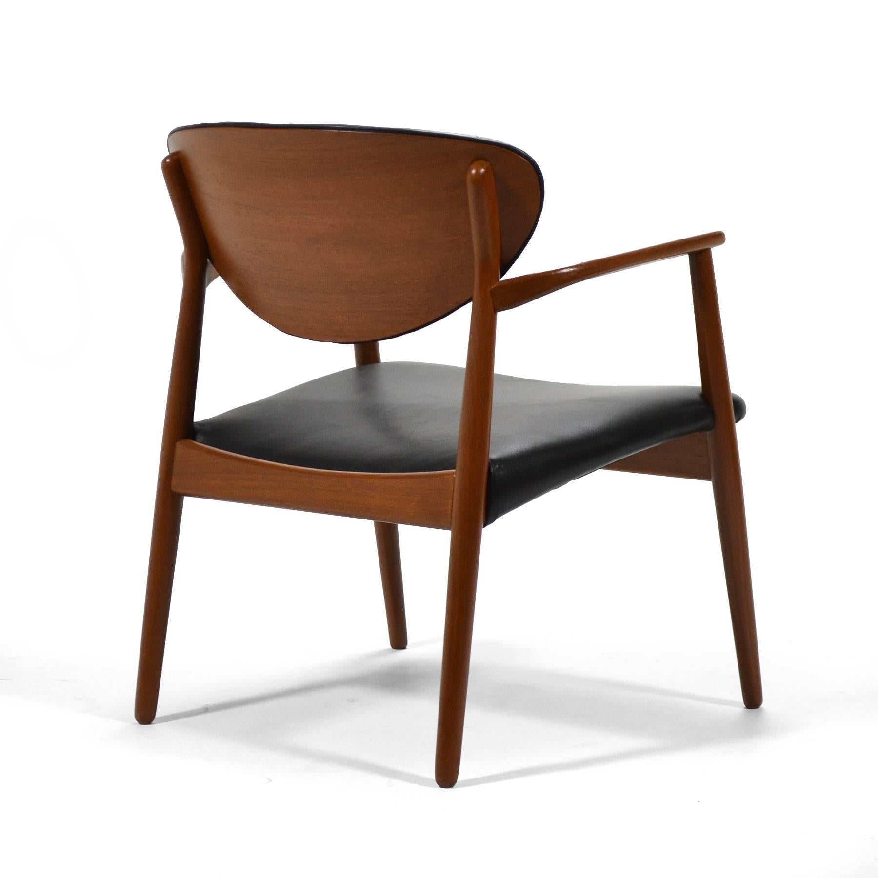 This handsome chair designed in 1959 by Ejnar Larsen and Aksel Bender Madsen for Næstved Møbelfabrik has a rakish stance and many wonderful details. The nicely scaled and comfortable chair has a sculptural teak frame with a newly upholstered black