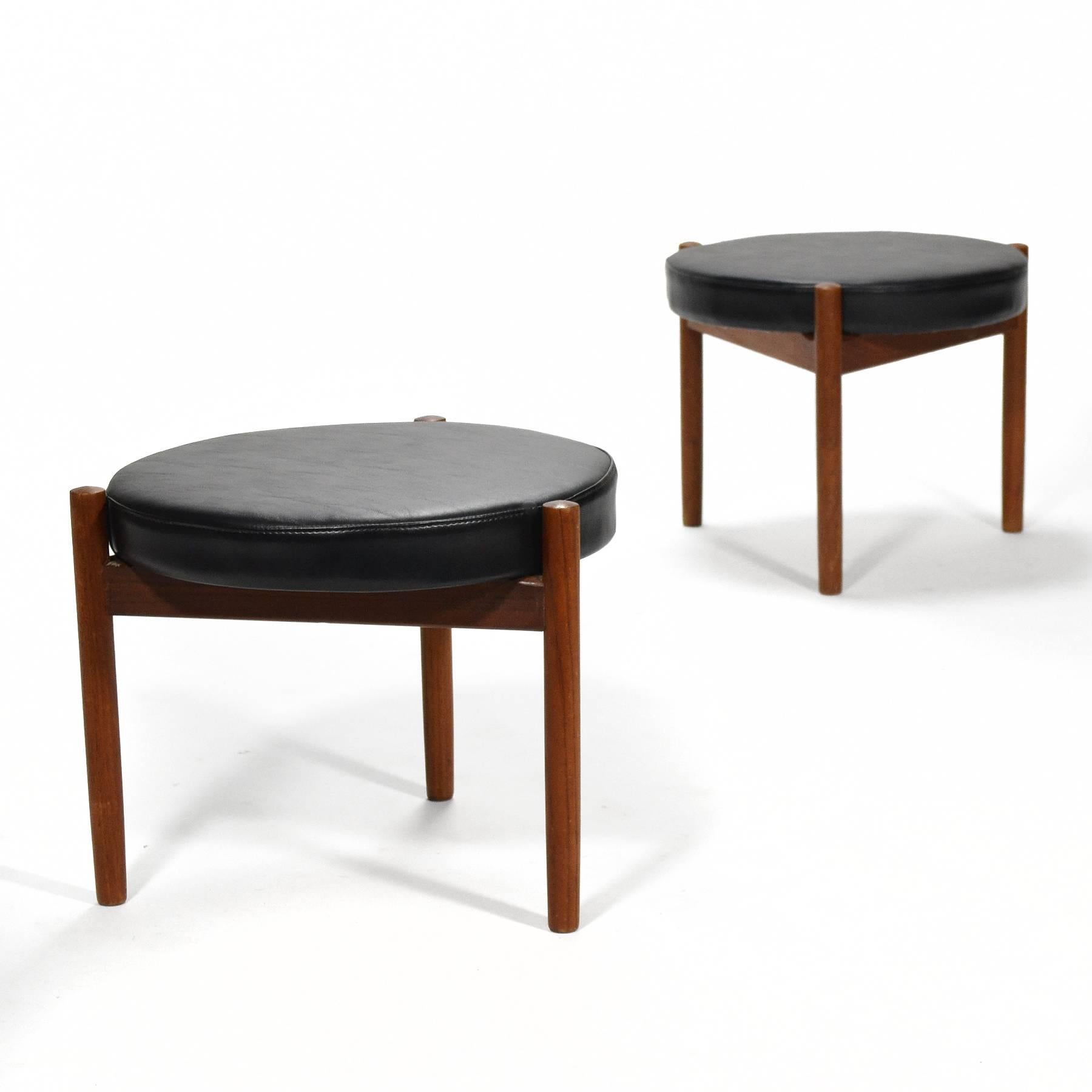 This charming and handsome pair of stools are also quite versatile. With a teak frame and legs which support and surround the seat cushion, they have a nice sculptural quality and a scale that makes them perfect occasional pieces. They function as