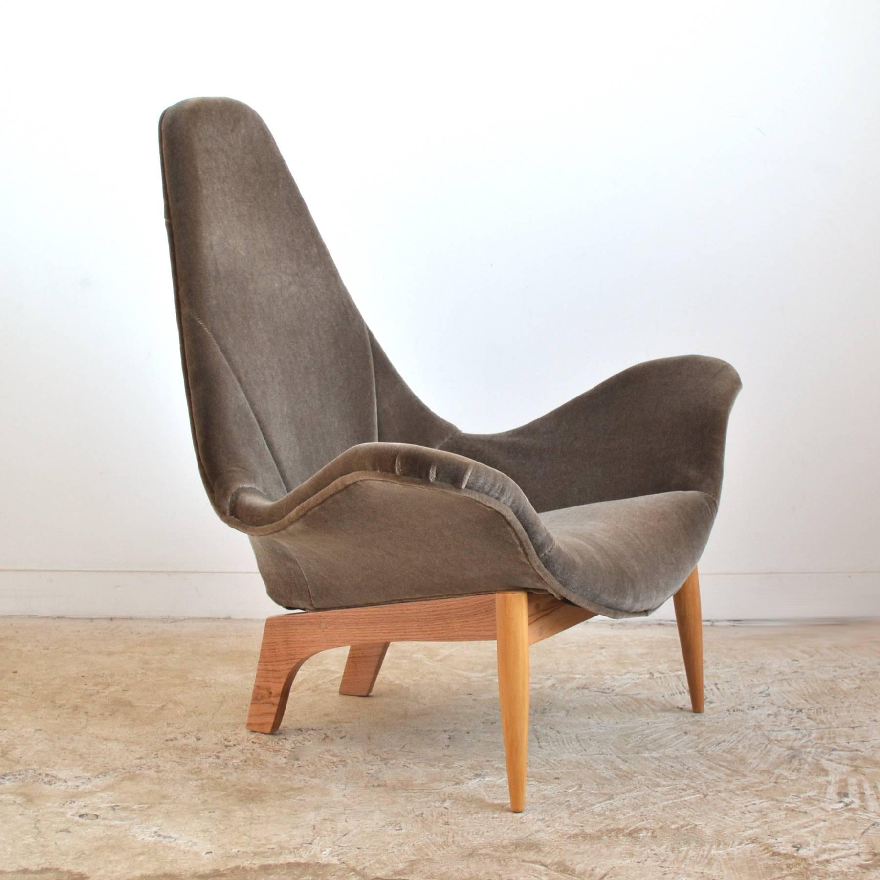 This early lounge chair by Adrian Pearsall is quite rare and shows his propensity for exuberant, sculptural forms. Unlike his later chair frames and bases of walnut, this chair has a base of maple and oak that supports a very expressive upholstered