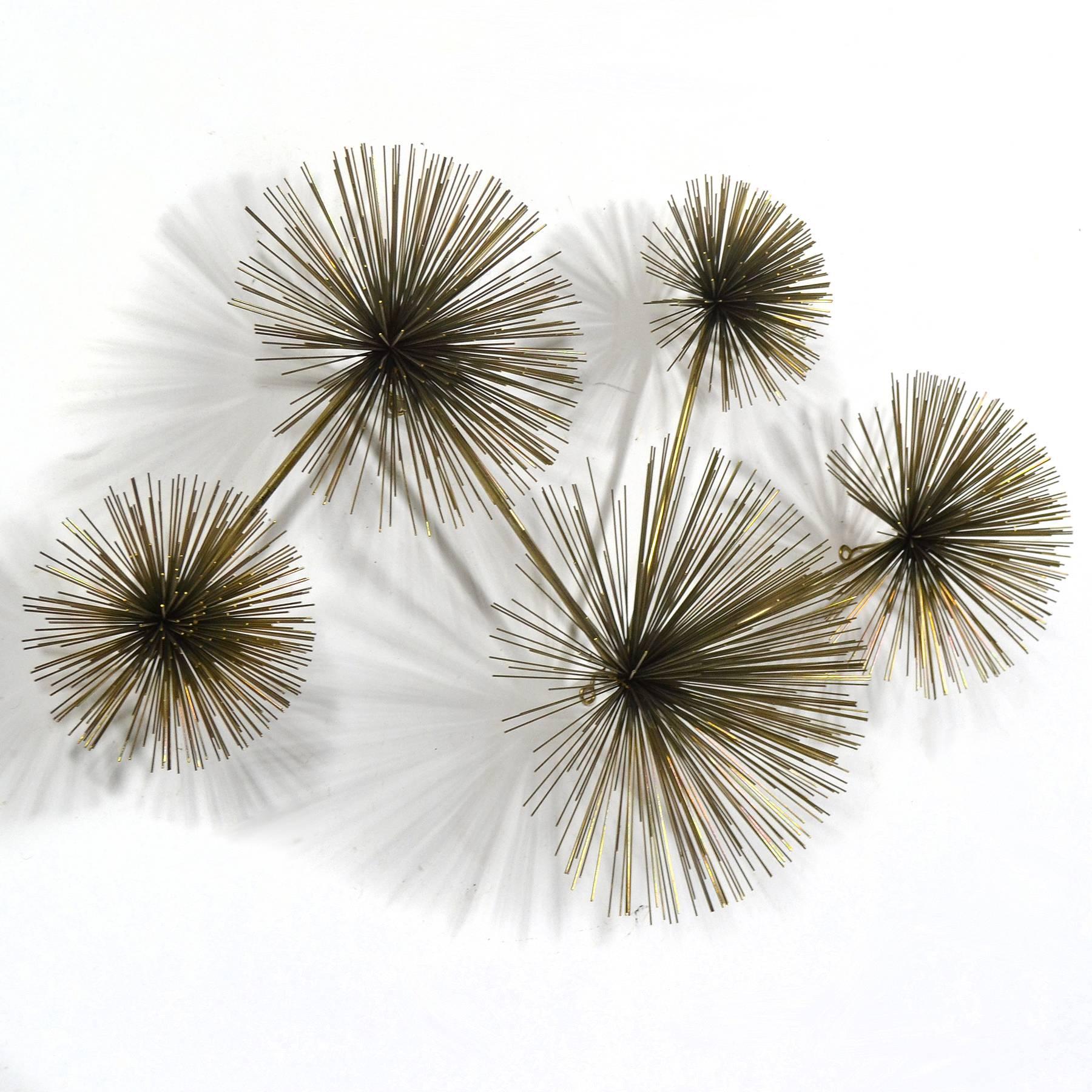 The Jere studio created a variety of designs using Bertoia's dandelion form as inspiration. This wall-mounted sculpture features a collection of five different sized bursts of radiating wire rods. A vibrant composition, it is equally attractive hung